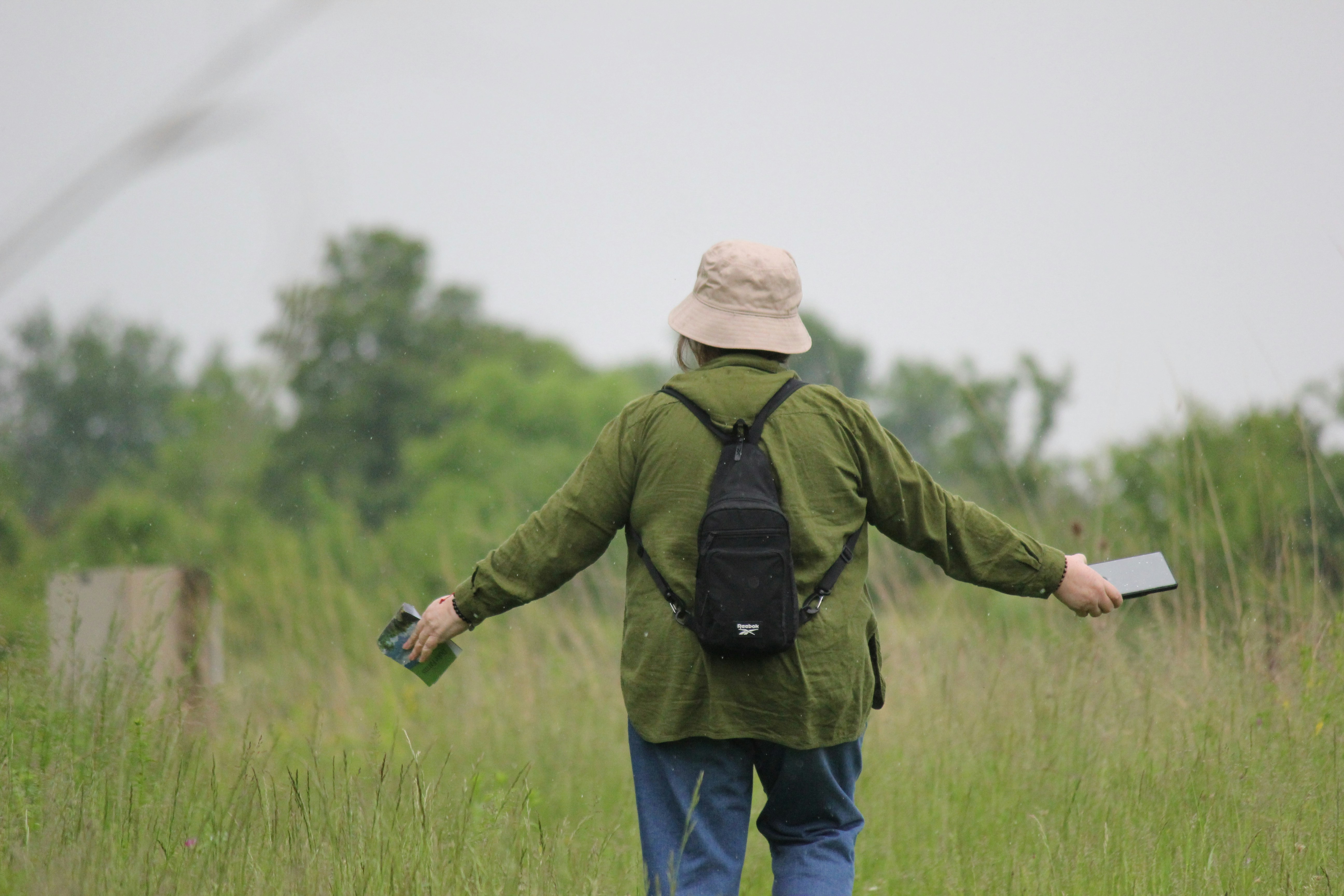 a person walking in a field with a backpack