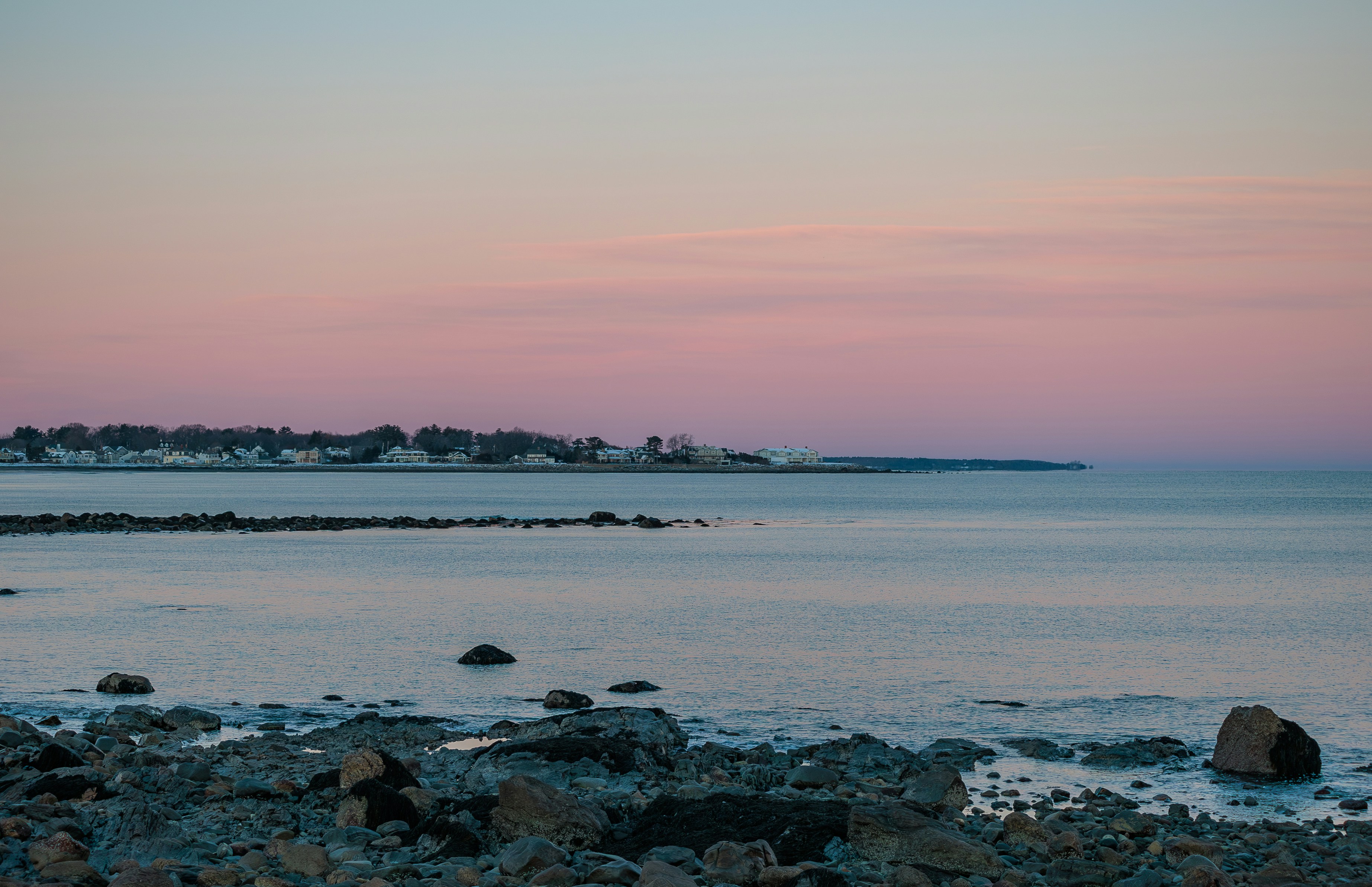 a body of water sitting next to a rocky shore