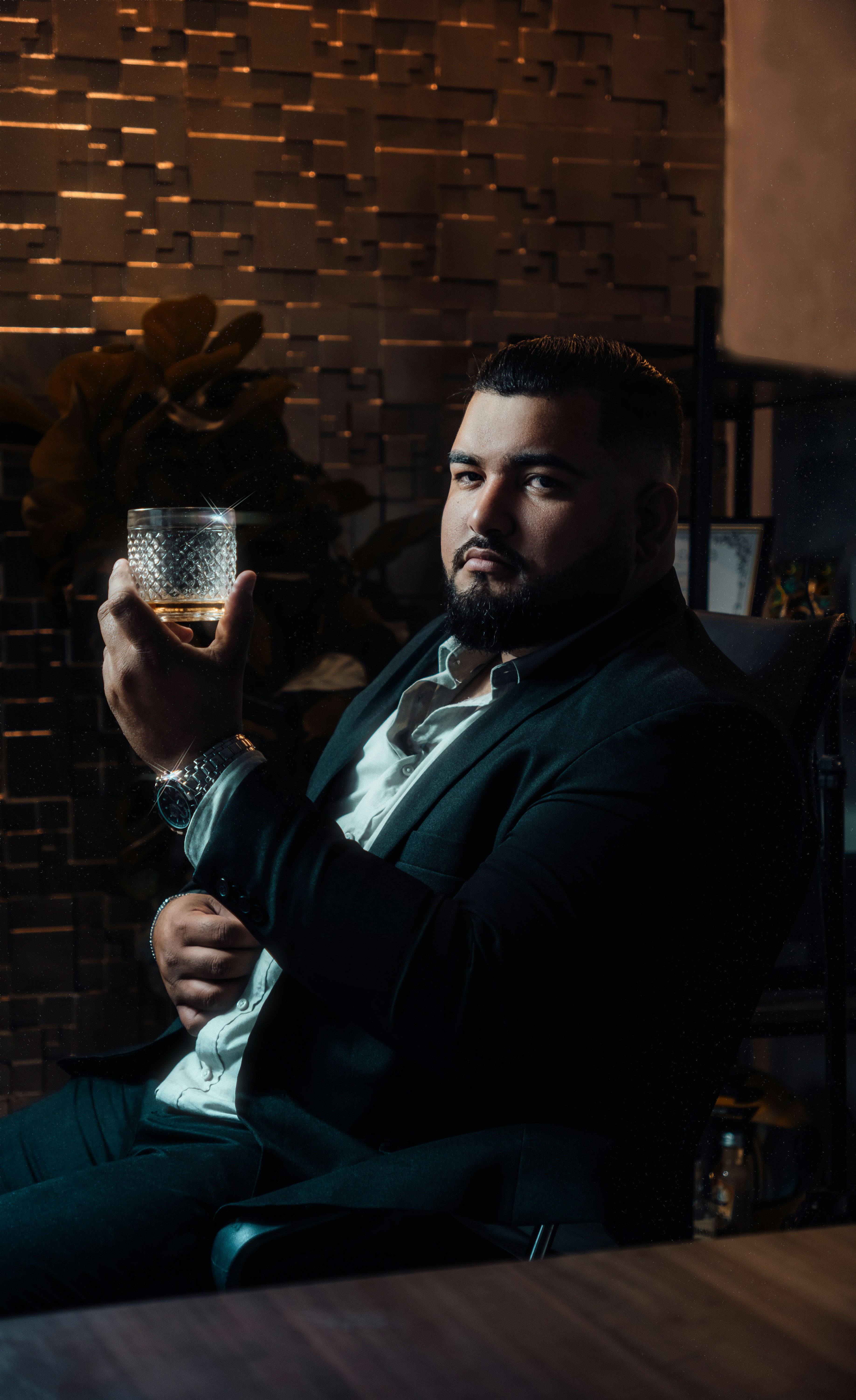 a man in a suit holding a glass of wine