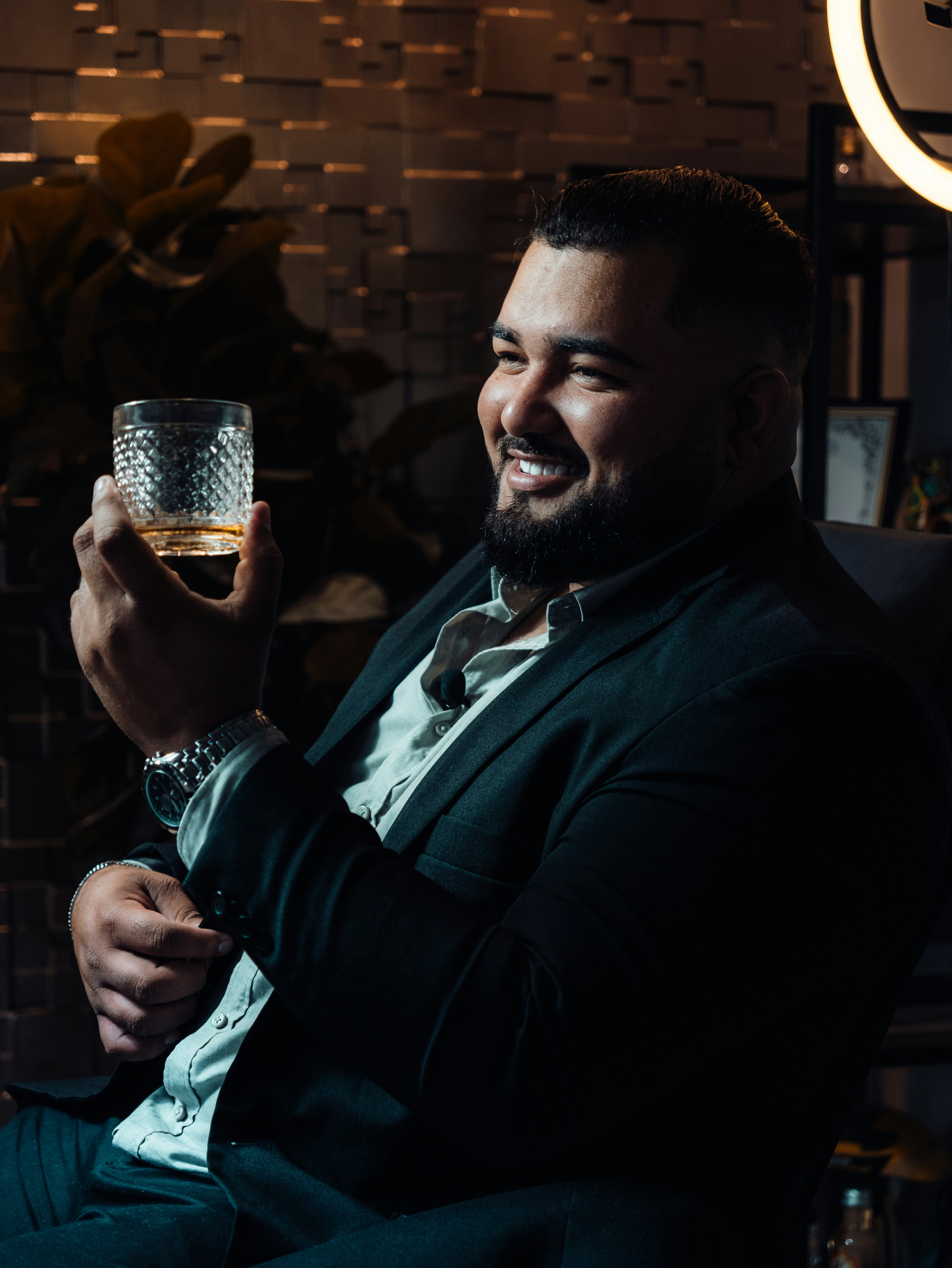 a man in a suit holding a glass of wine