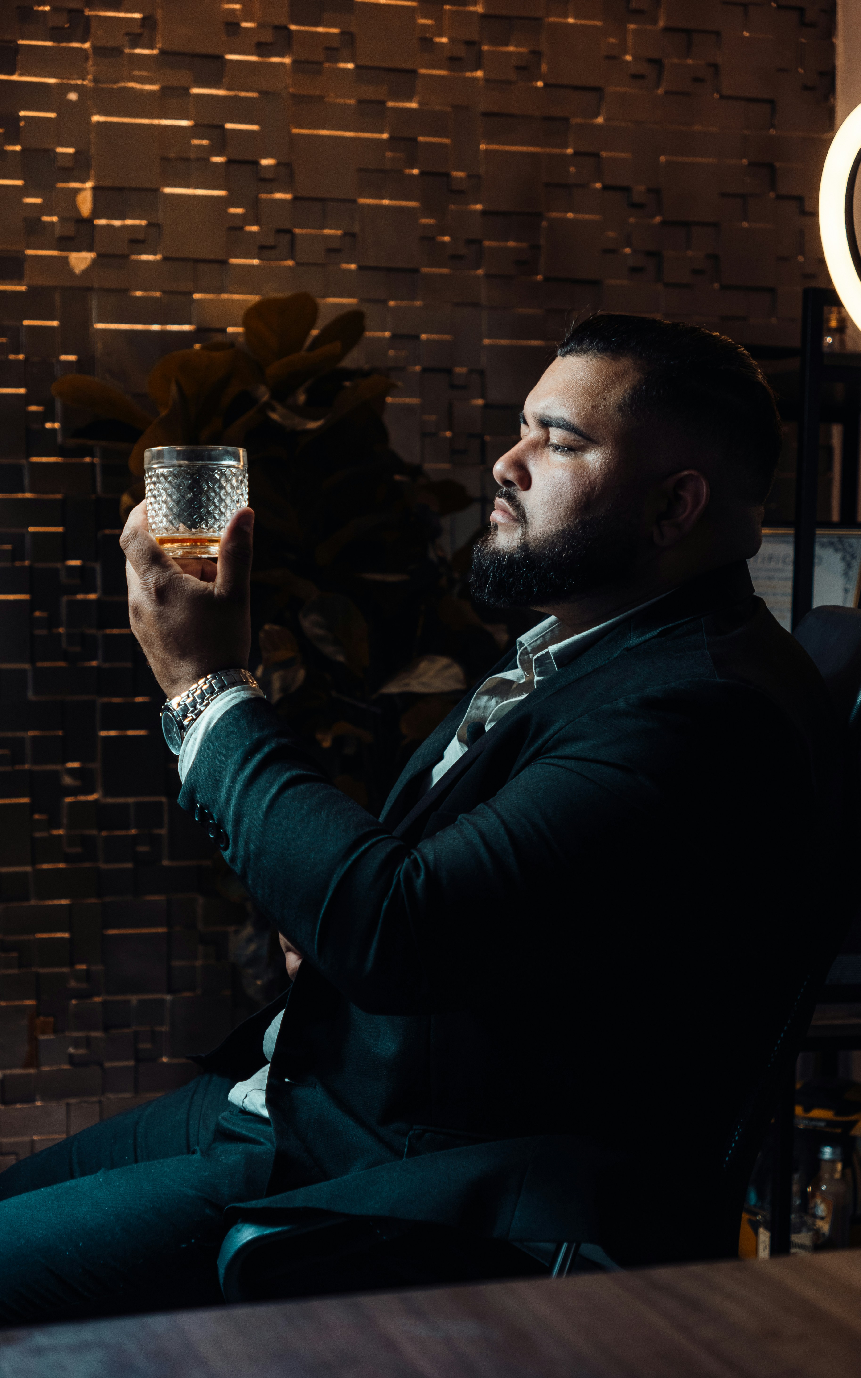 a man sitting in a chair holding a glass