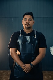 a man in a black apron standing in a room
