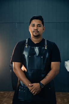 a man in a black apron standing in a room