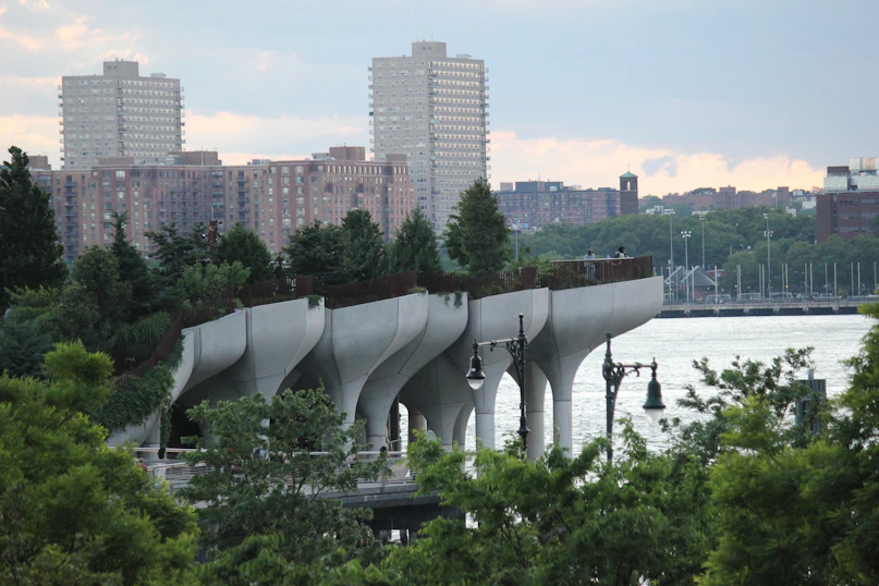 a view of a bridge over a body of water with tall buildings in the background