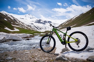 a mountain bike parked on a rocky shore