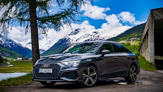 a grey car parked in front of a mountain