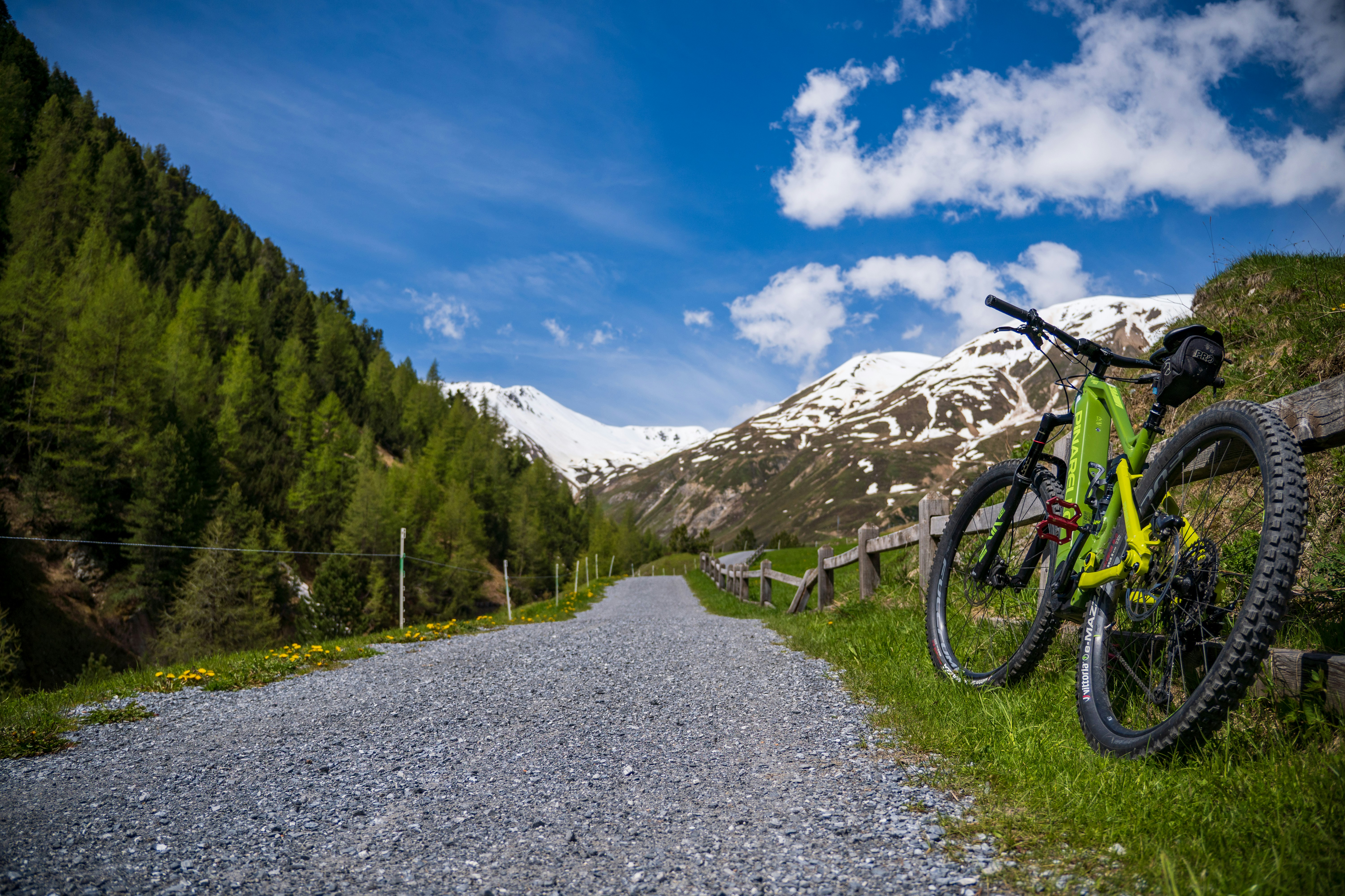 a bike leaning against a fence on a gravel road