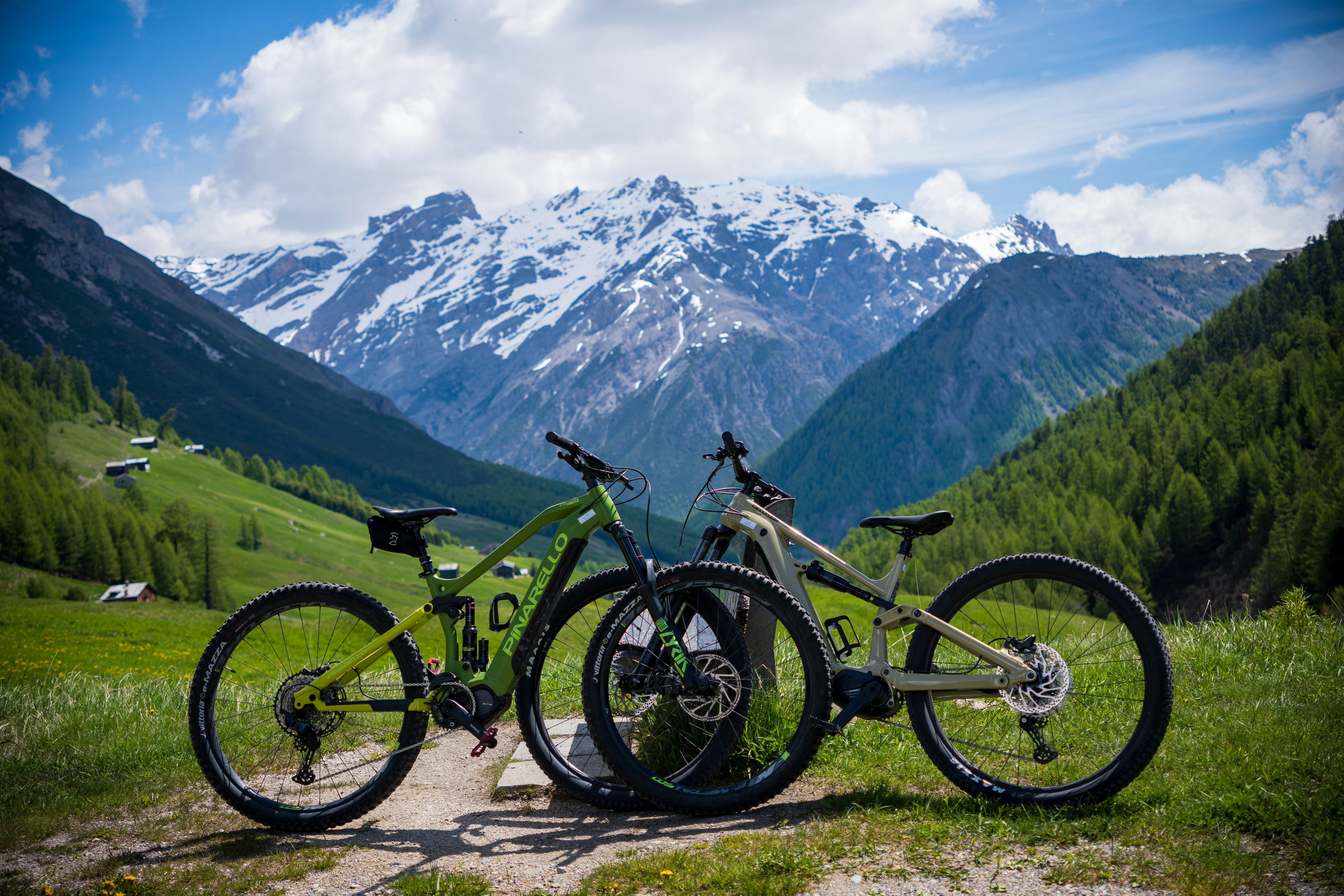 two mountain bikes parked on a trail in the mountains