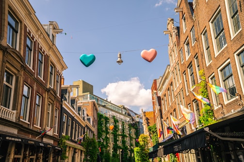 a couple of heart shaped balloons hanging from a line