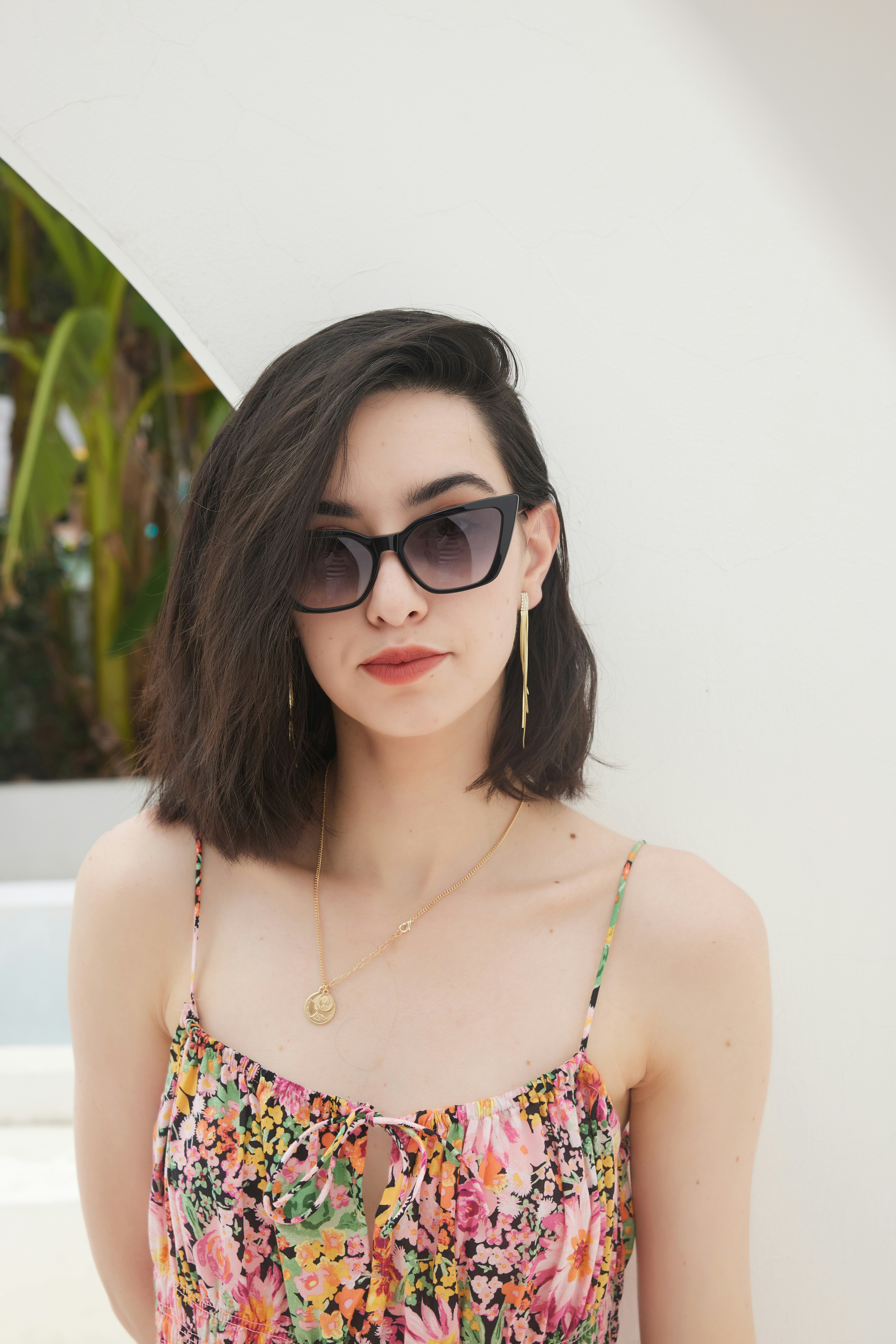 a woman wearing sunglasses and a floral top