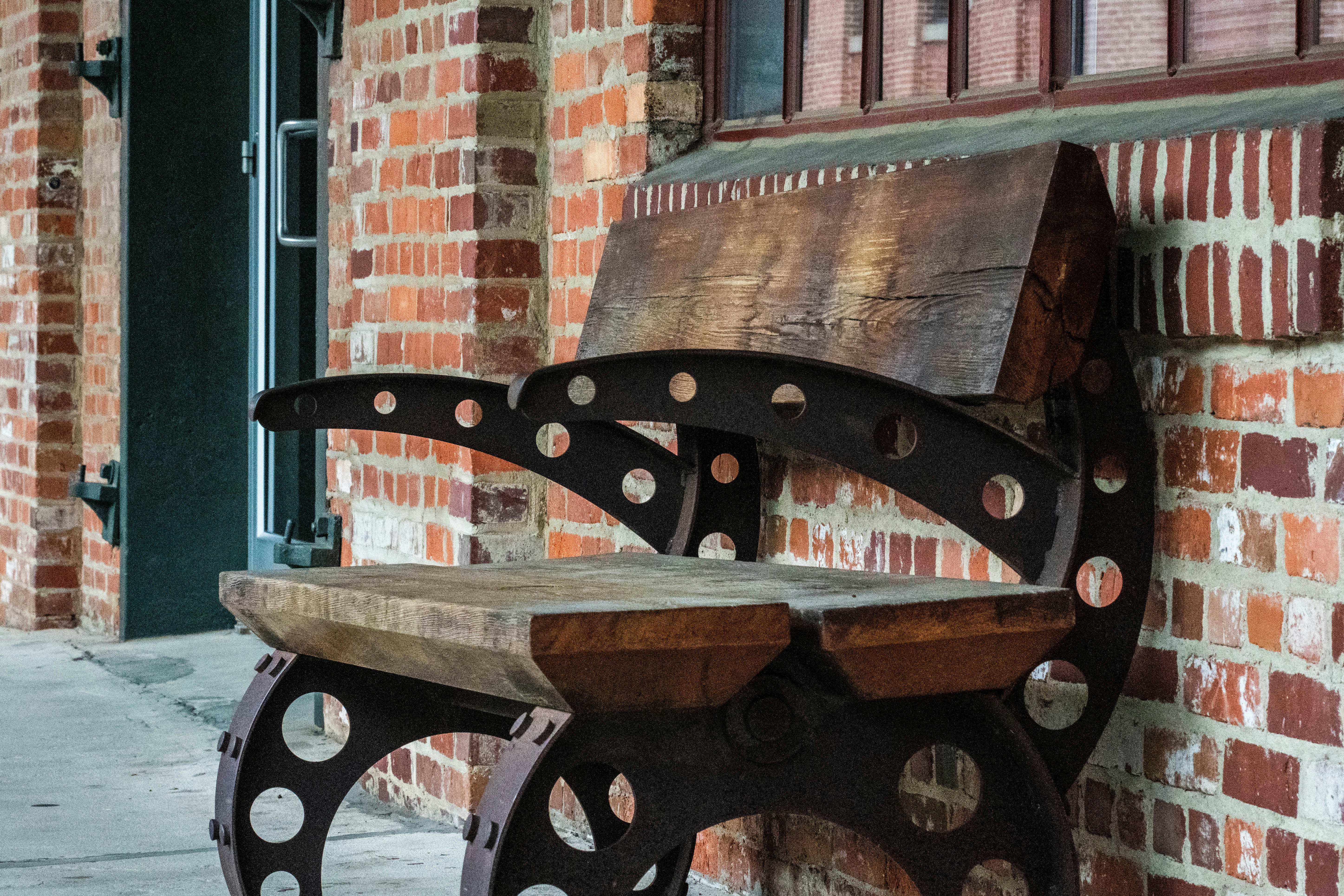 a wooden bench sitting next to a brick building