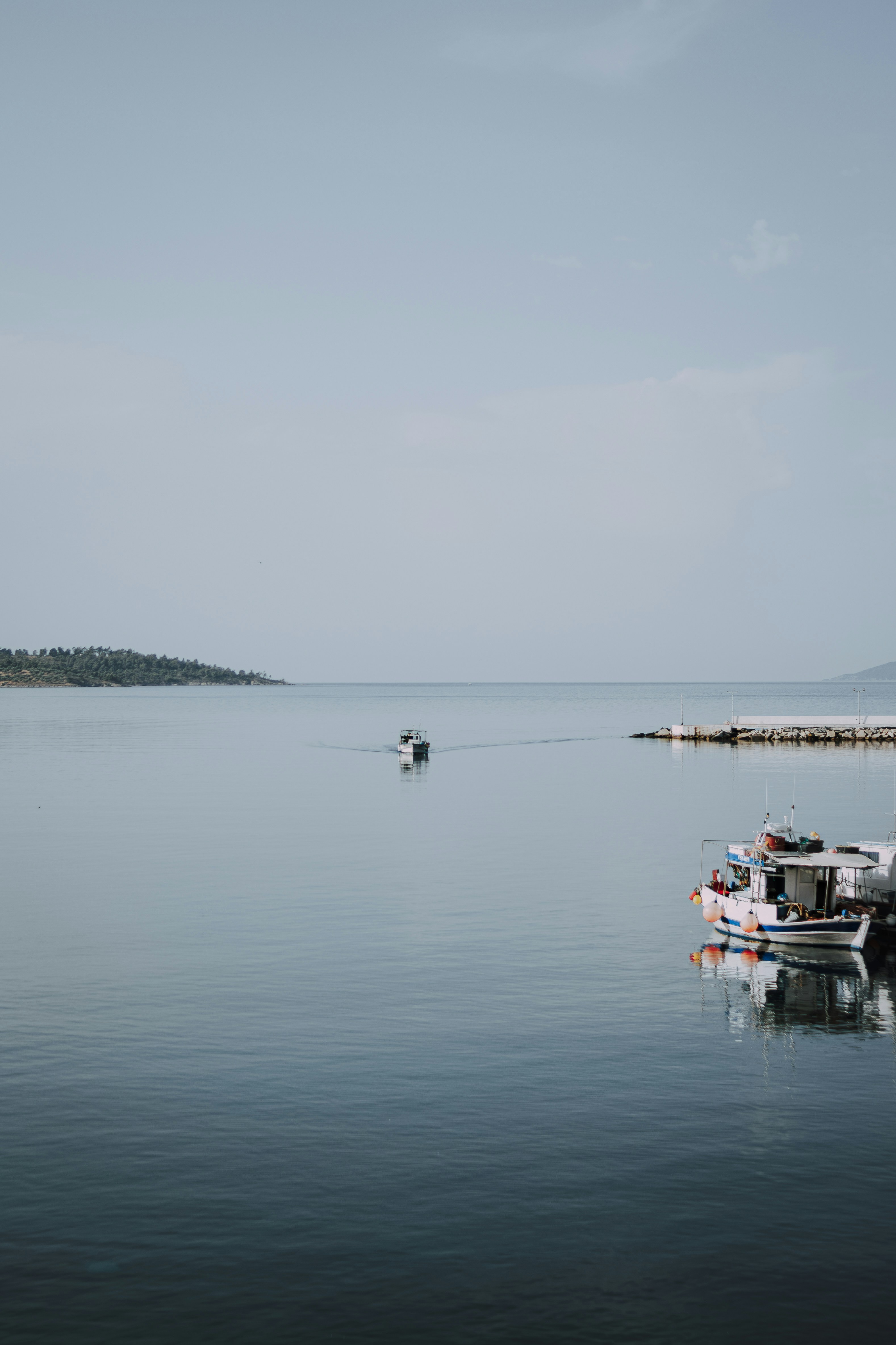 a couple of boats floating on top of a large body of water