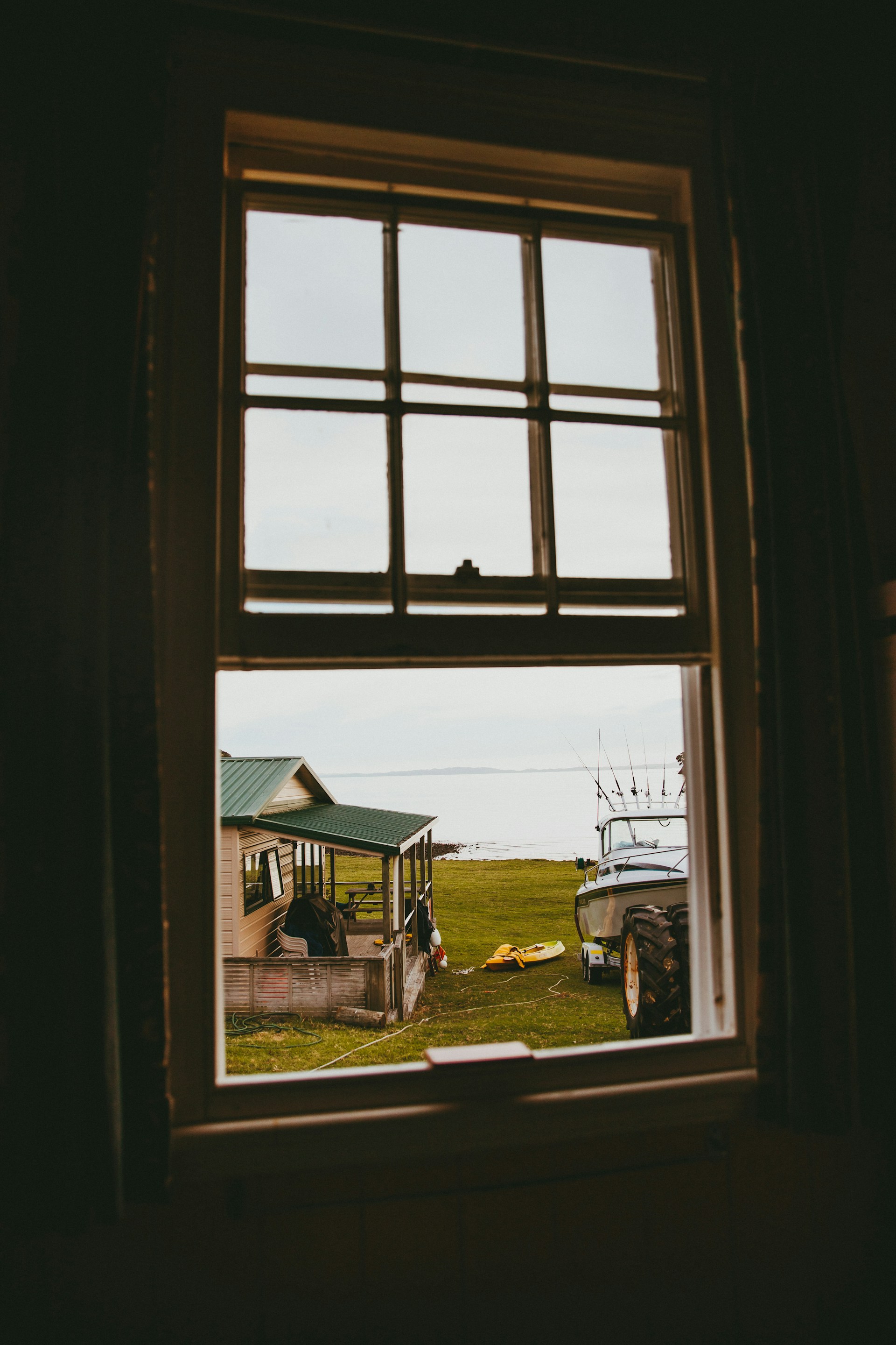 a window with a view of a truck and a house