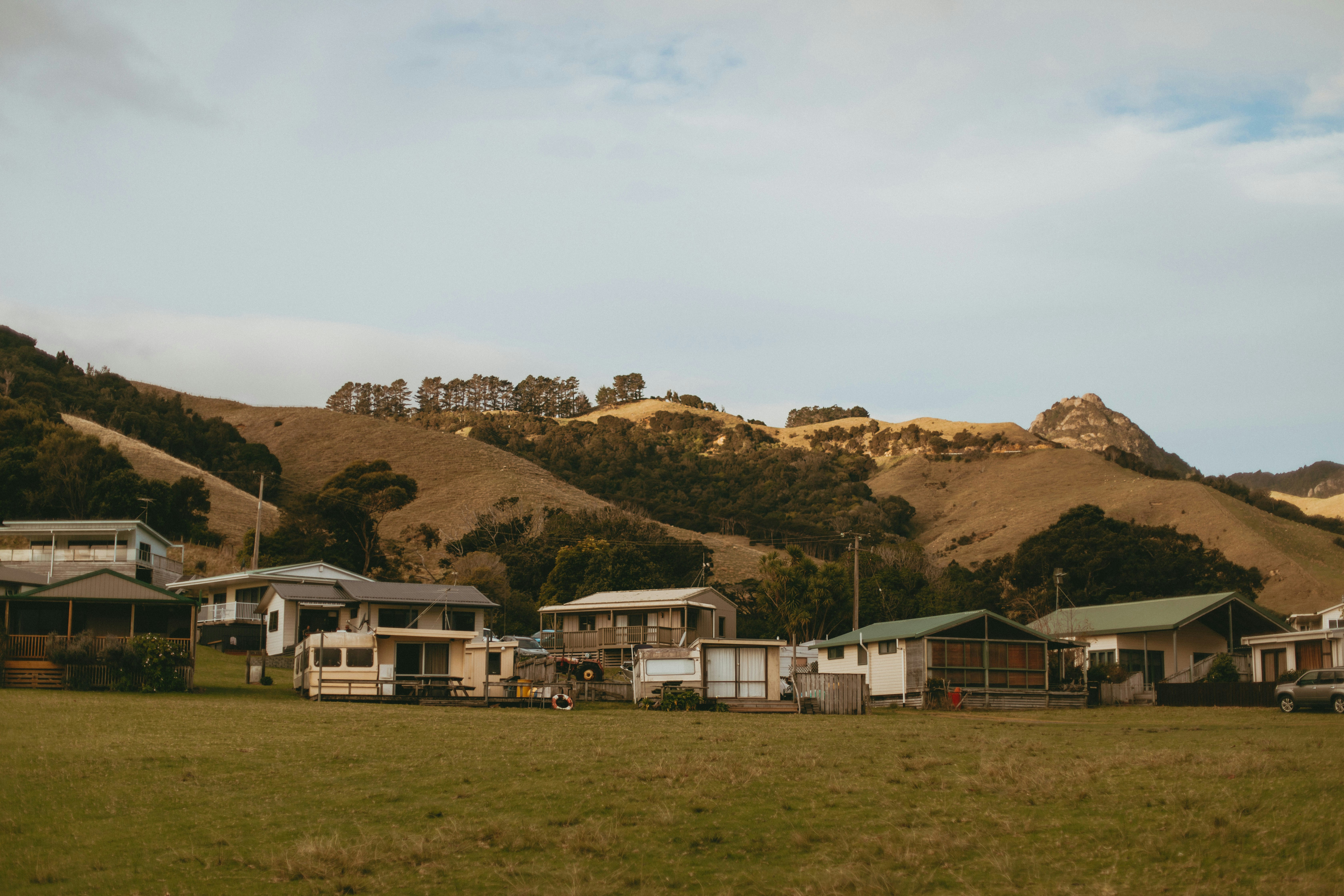 a group of houses sitting on top of a lush green field