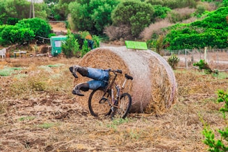 a bicycle leaning against a bale of hay