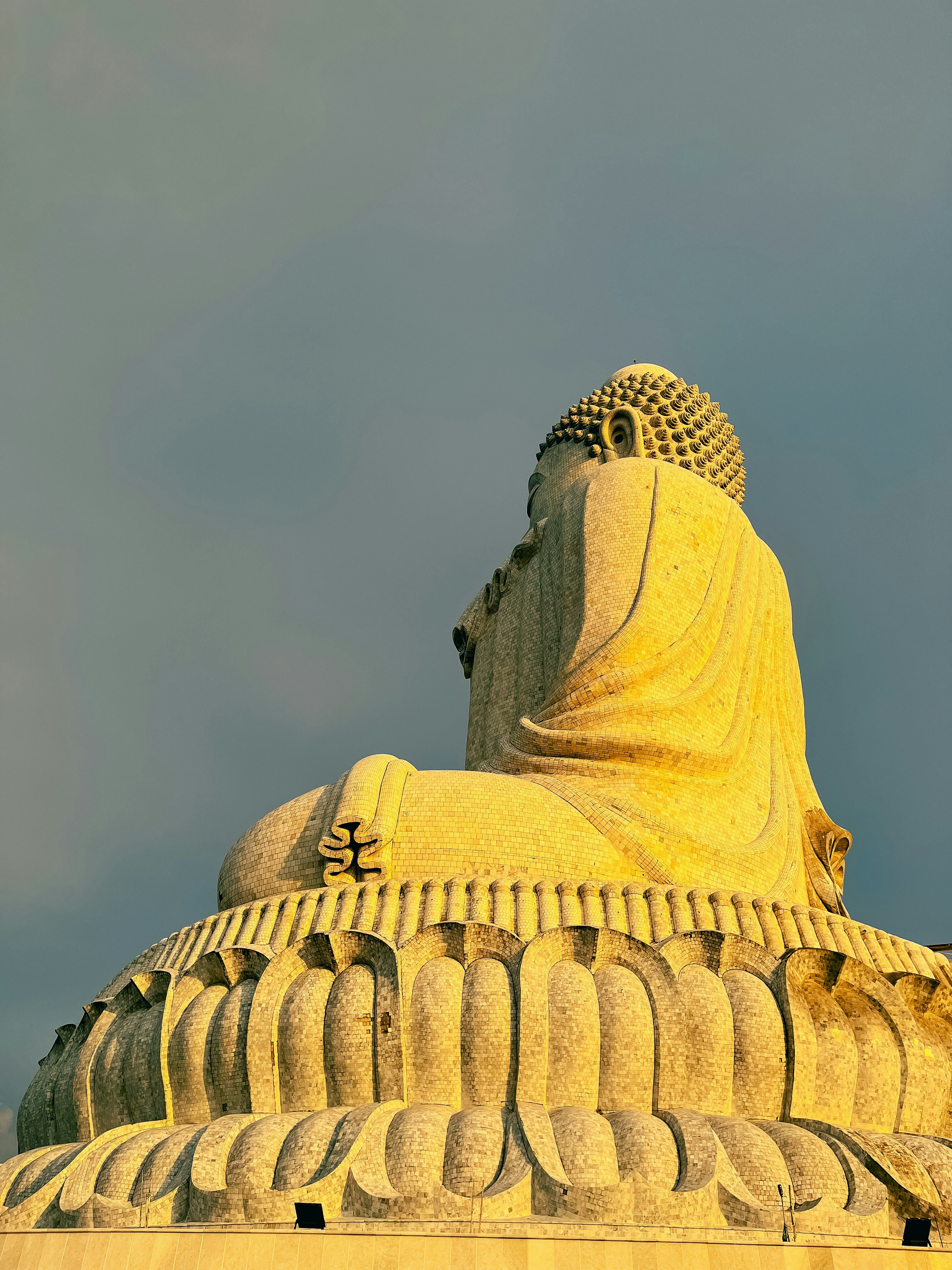 a large statue of a buddha sitting on top of a building
