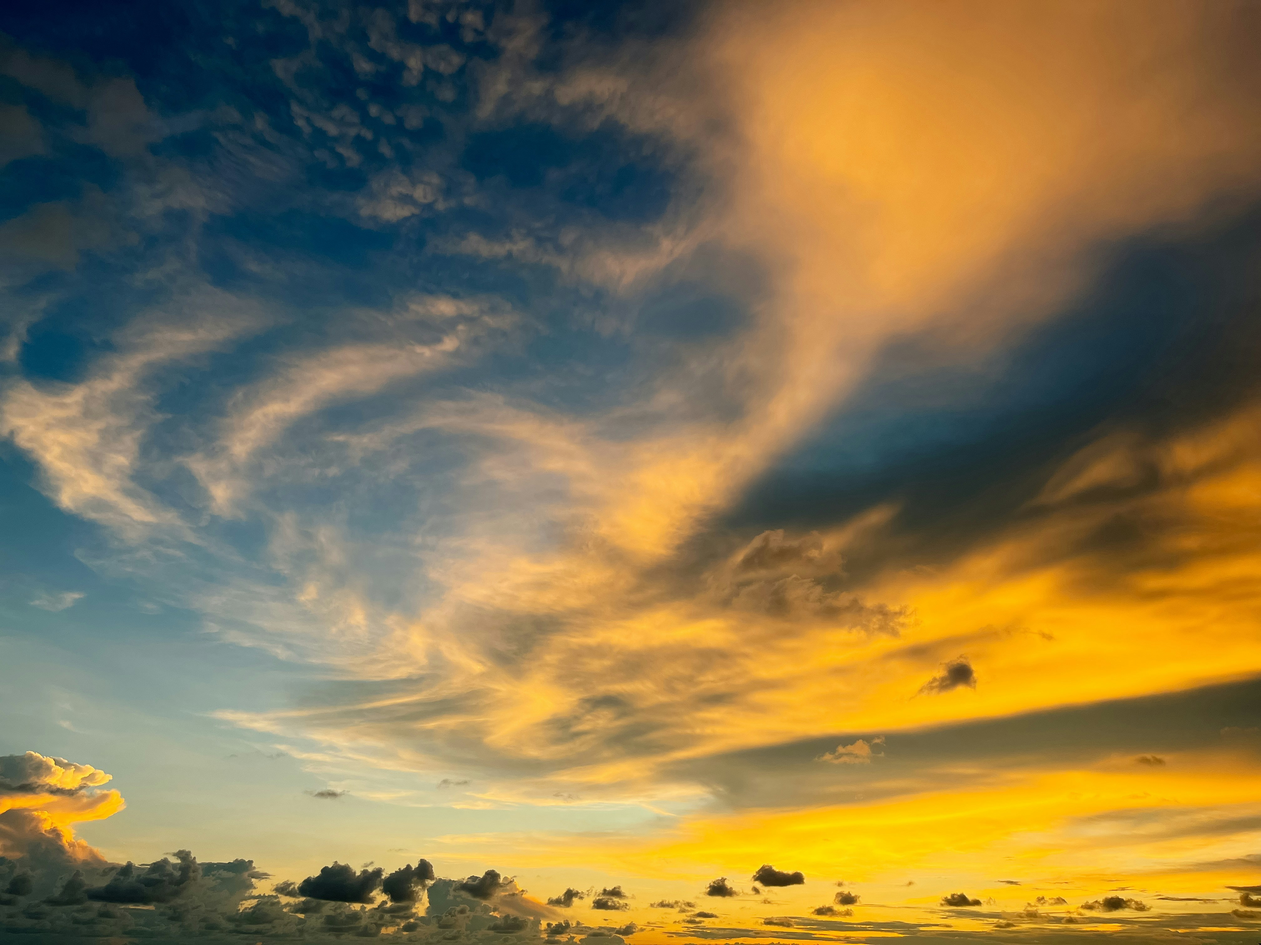 a plane flying in the sky at sunset