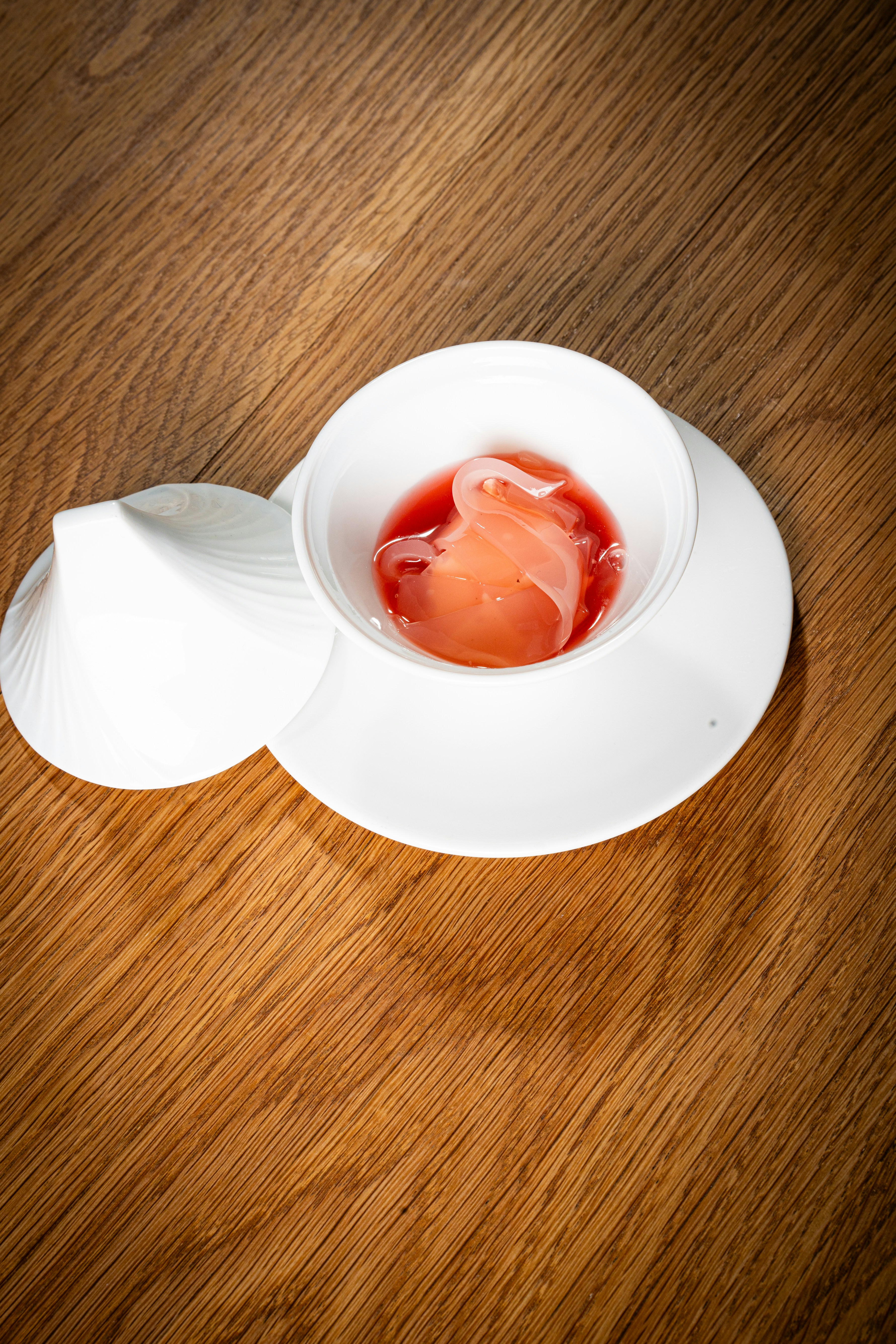 a white bowl filled with sauce on top of a wooden table