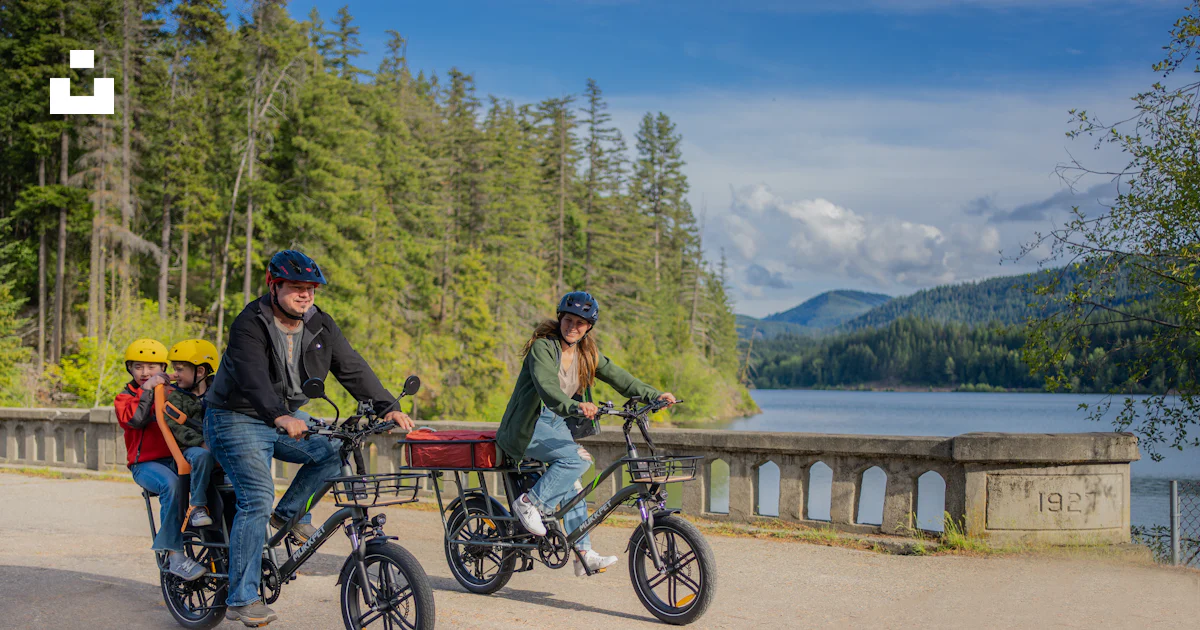 Riding In Bike A couple of people riding bikes down a road photo – Free Bicycle Image ...