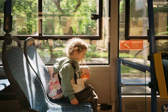 a small child sitting on a bus seat
