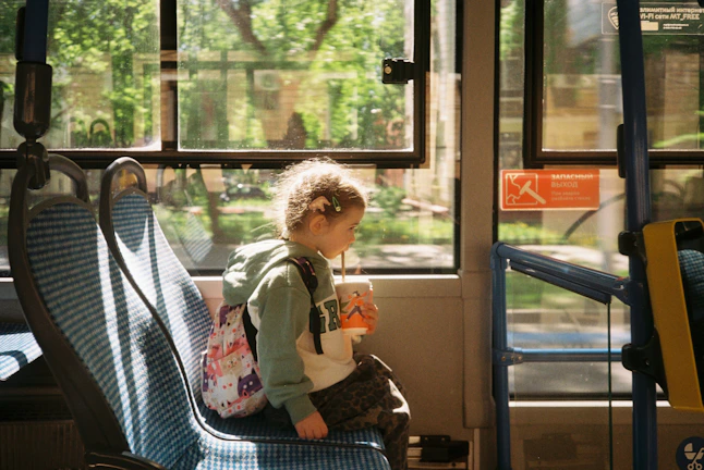 a small child sitting on a bus seat