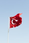 a flag flying in the wind on a clear day