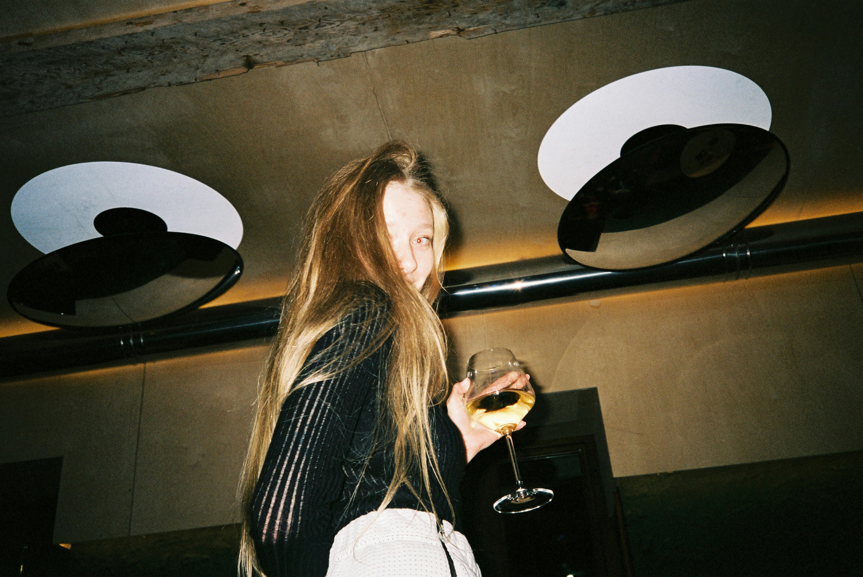 a woman holding a glass of wine in her hand