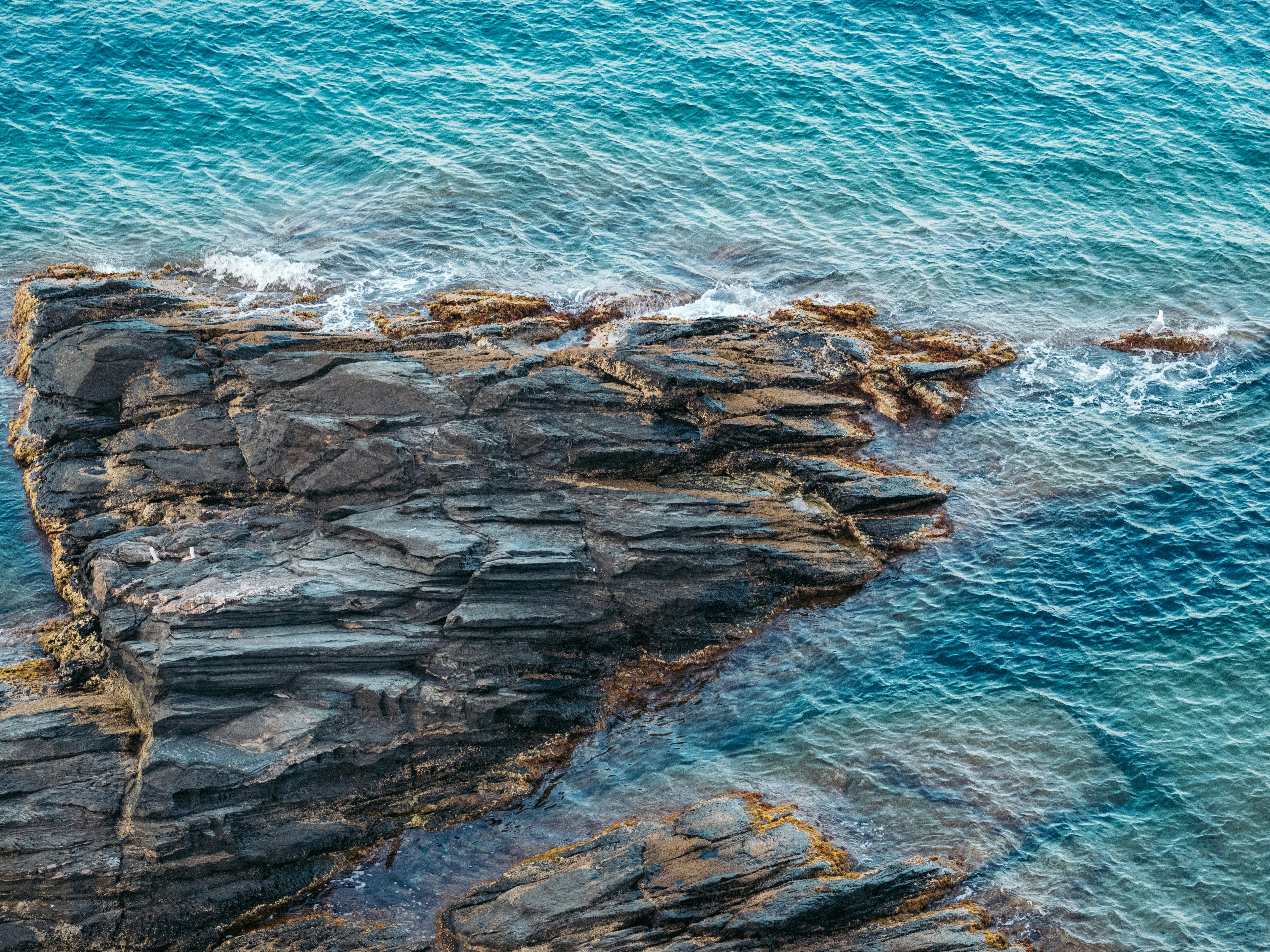 an aerial view of a rock formation in the ocean