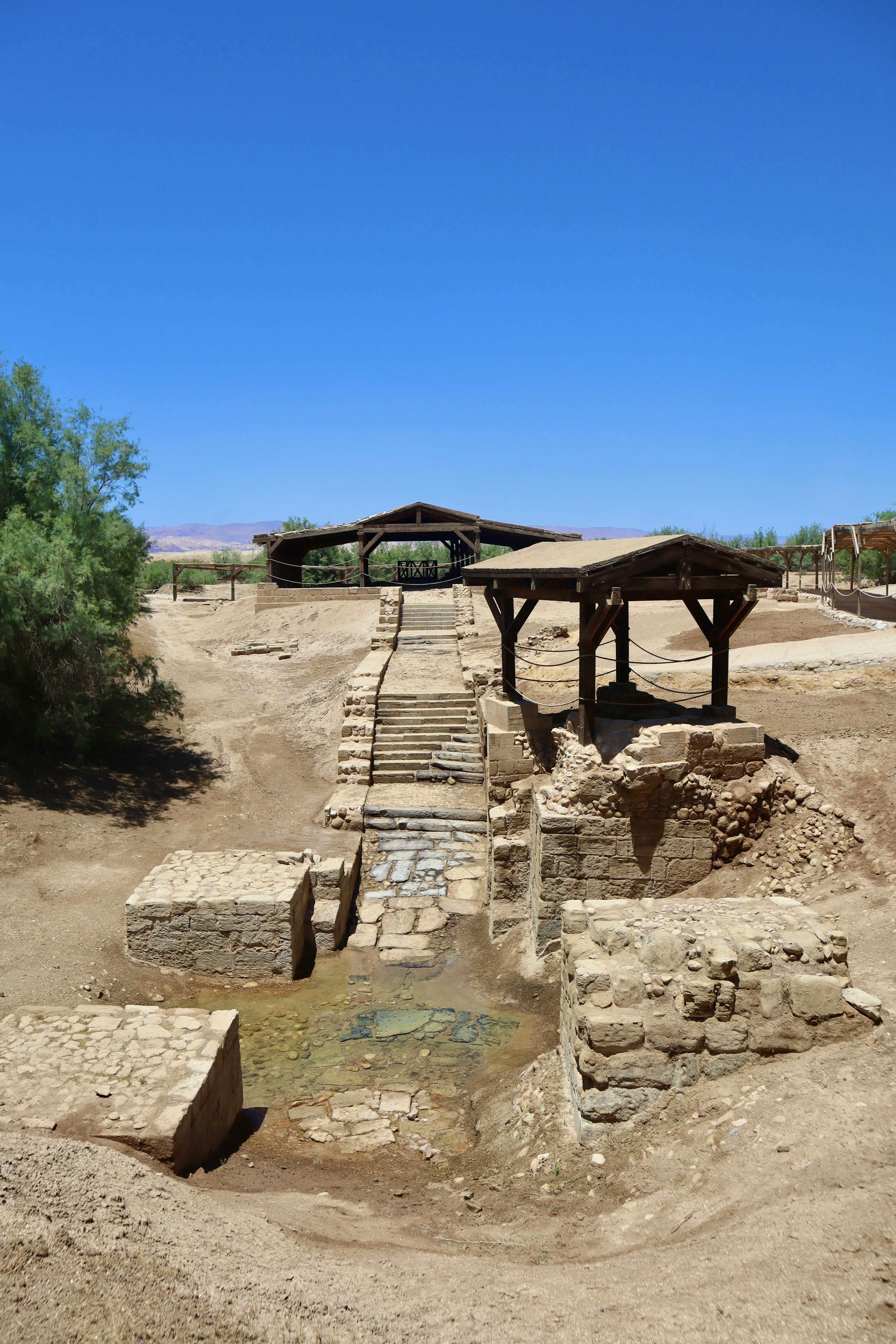 a small bridge over a small stream in the middle of a desert