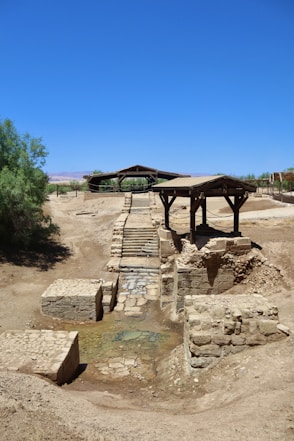 a small bridge over a small stream in the middle of a desert