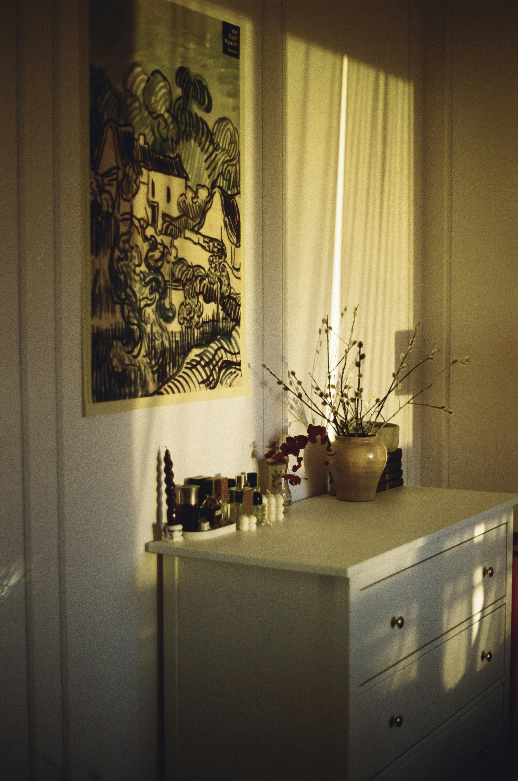 a room with a dresser and a painting on the wall