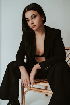a woman sitting on top of a wooden chair