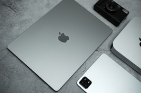 a silver apple laptop sitting on top of a table