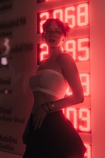 a woman standing in front of a neon sign