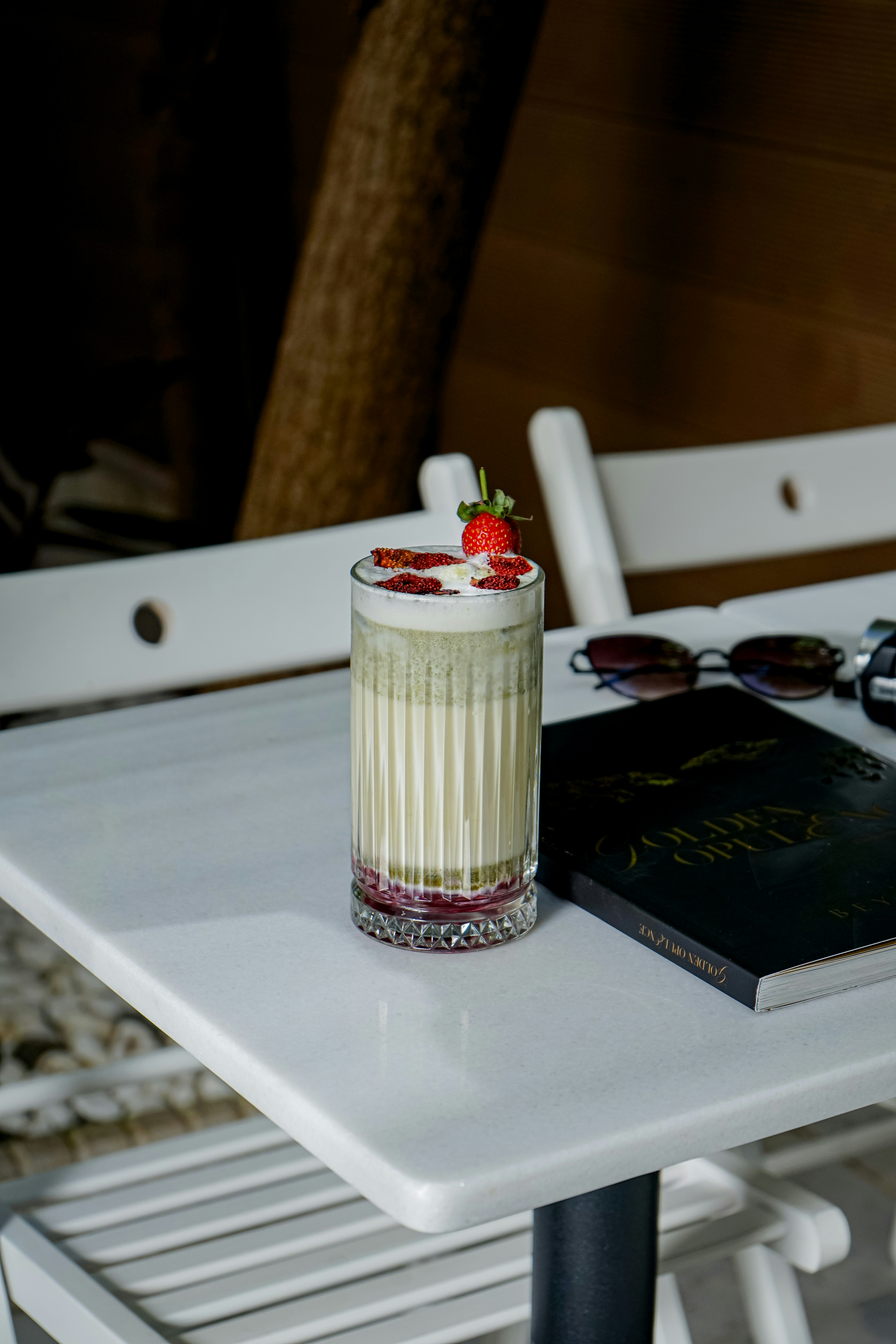 uma mesa com um livro e uma bebida