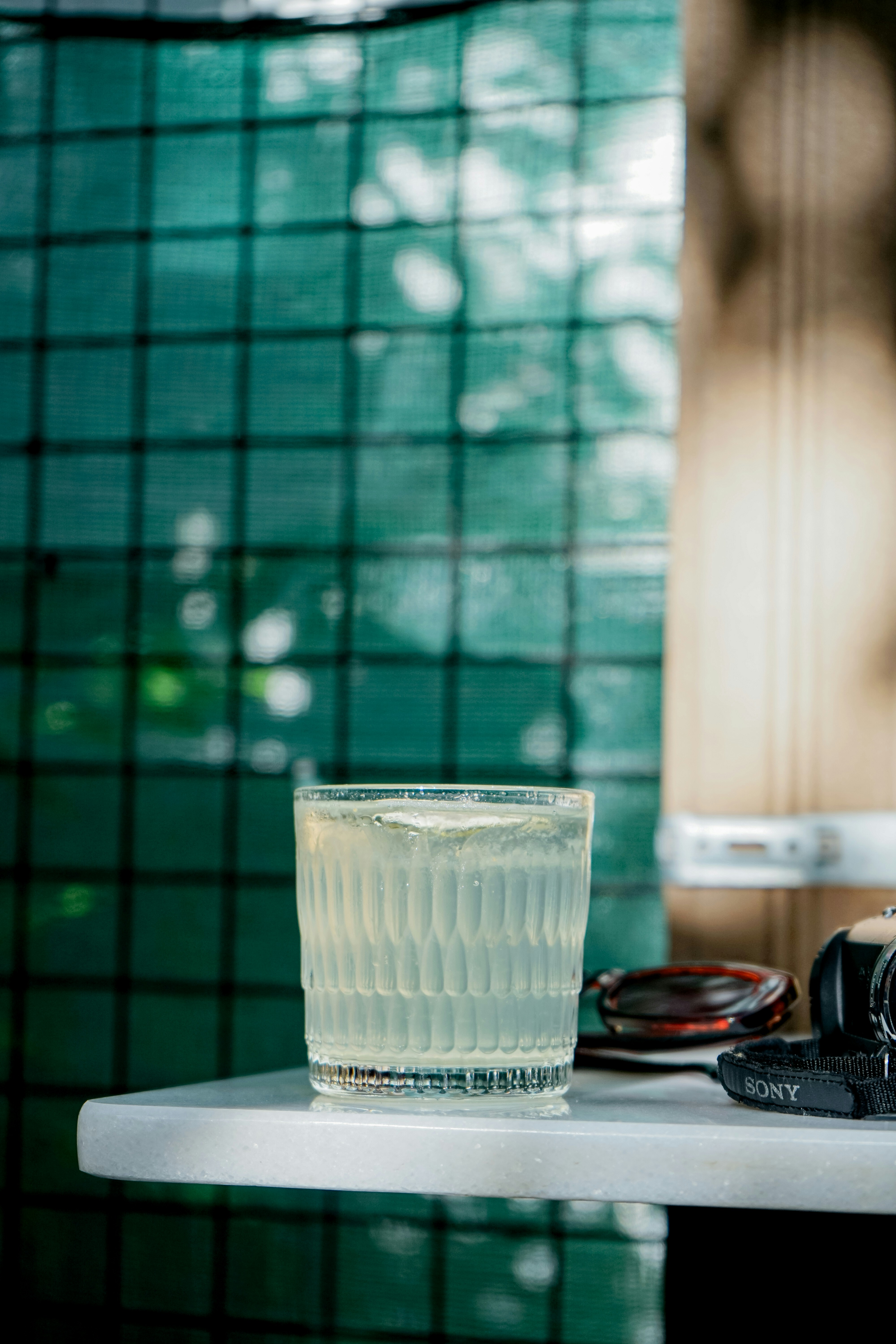 um copo de água e uma câmera sobre uma mesa