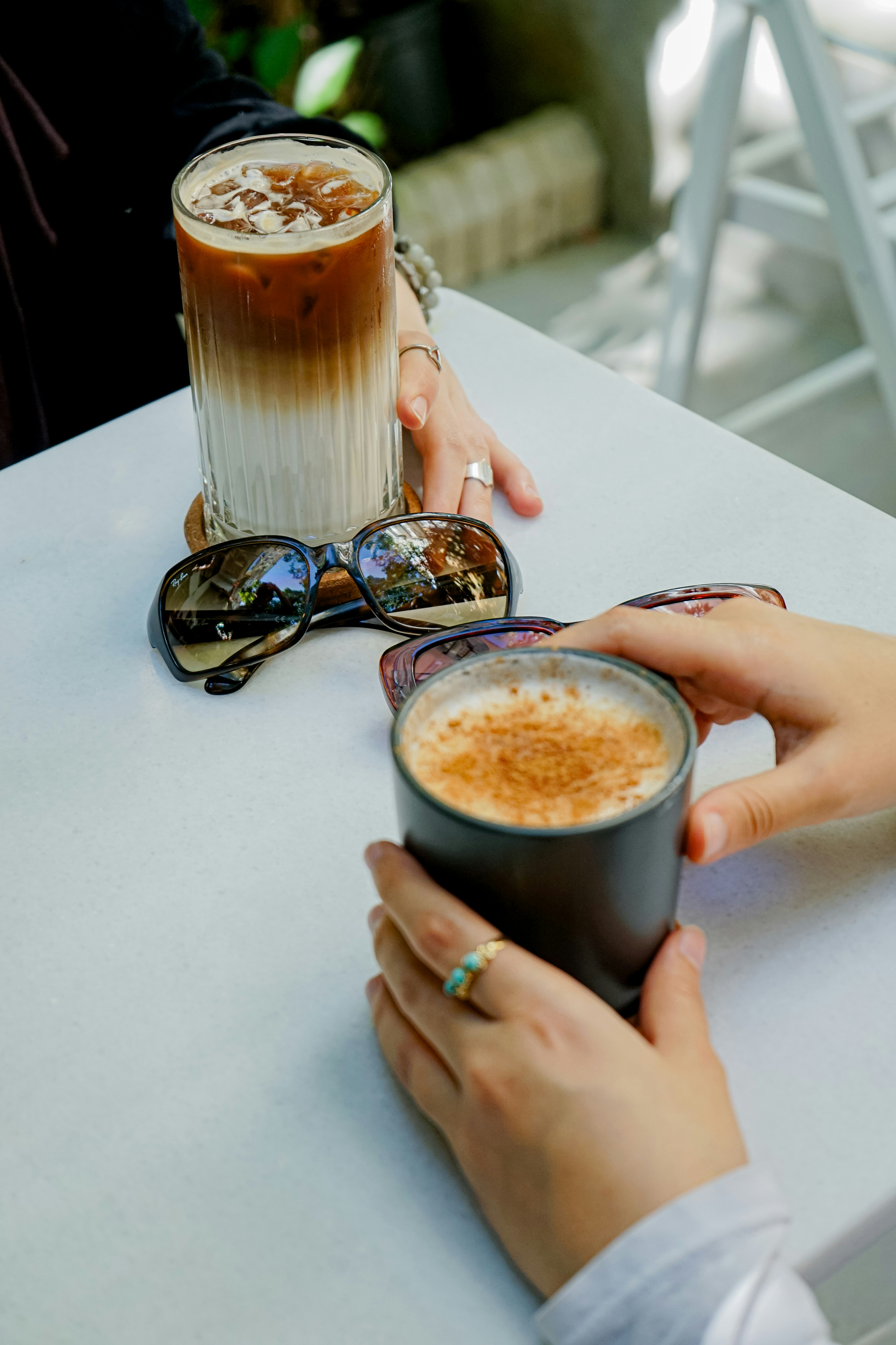 uma pessoa segurando uma xícara de café em uma mesa