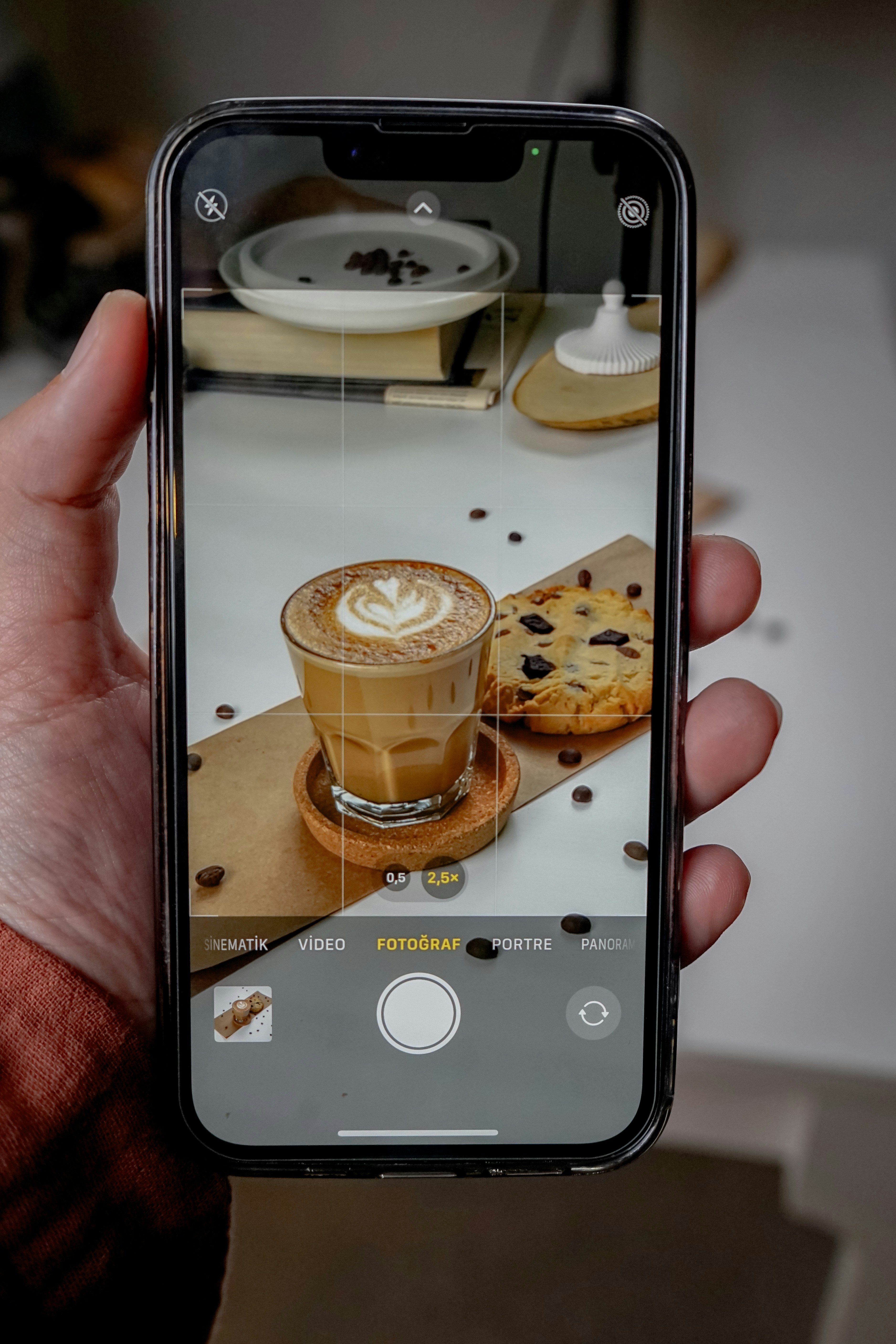 uma pessoa tirando uma foto de uma xícara de café