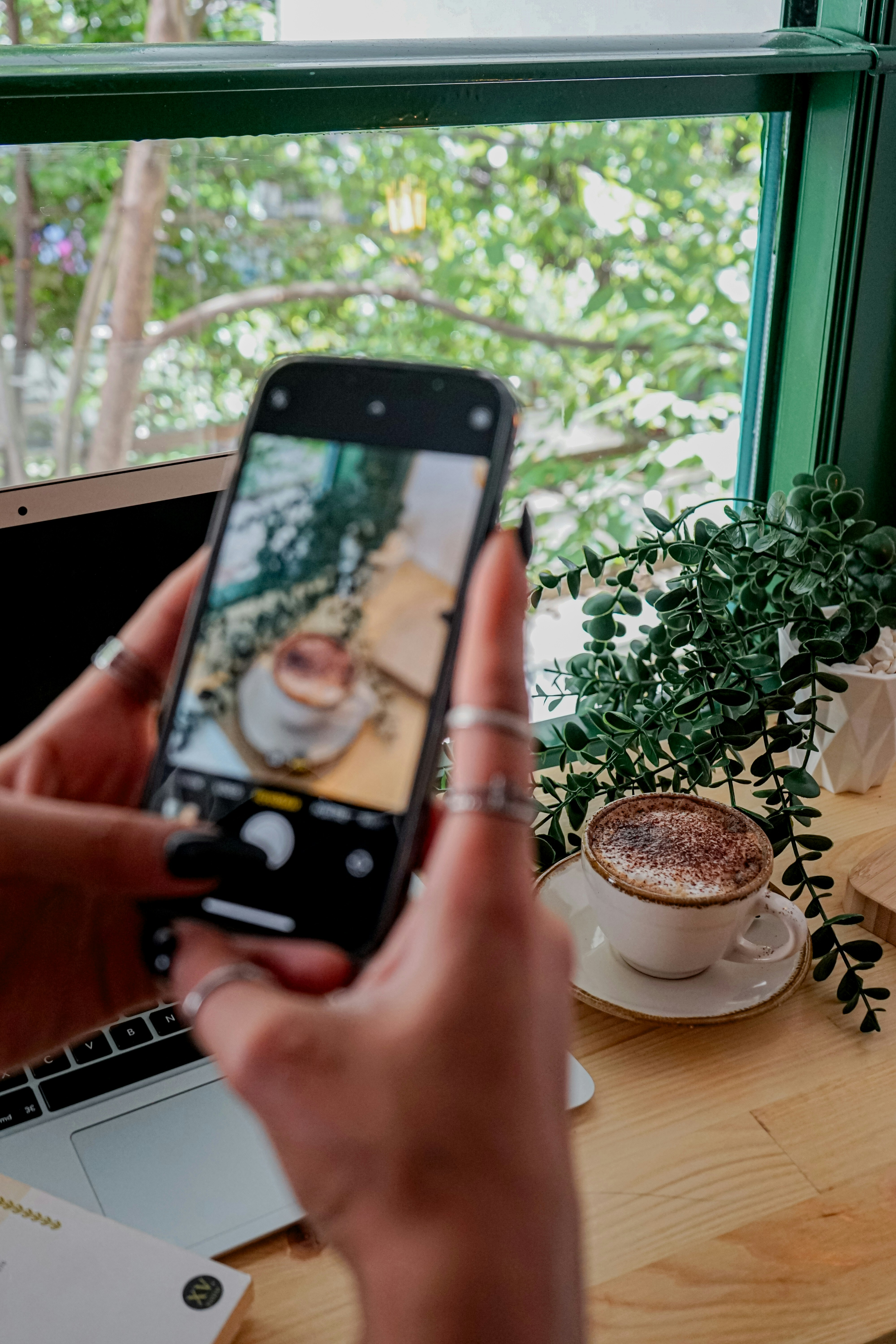 uma pessoa tirando uma foto de uma xícara de café