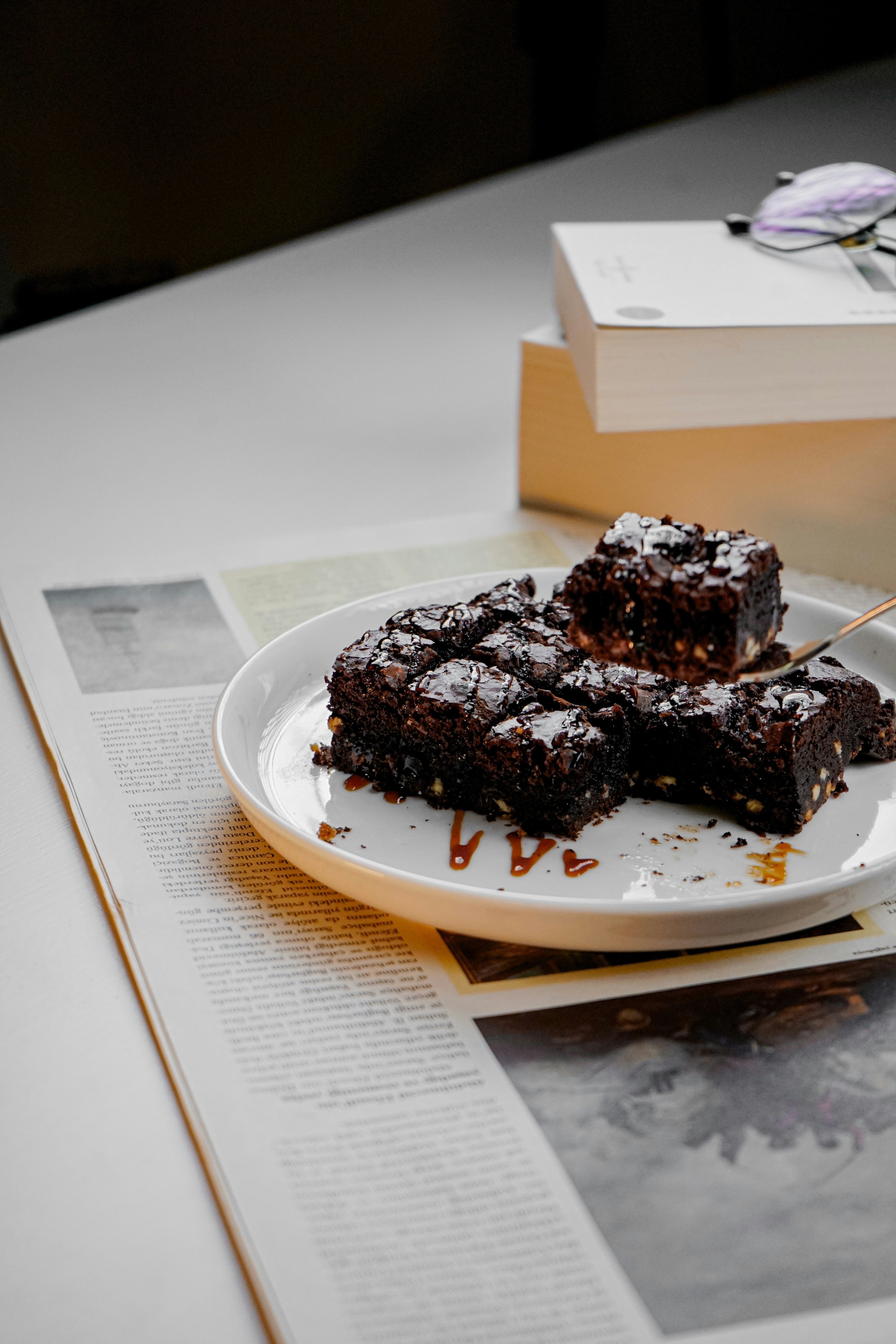 um prato branco coberto com brownies em cima de uma mesa