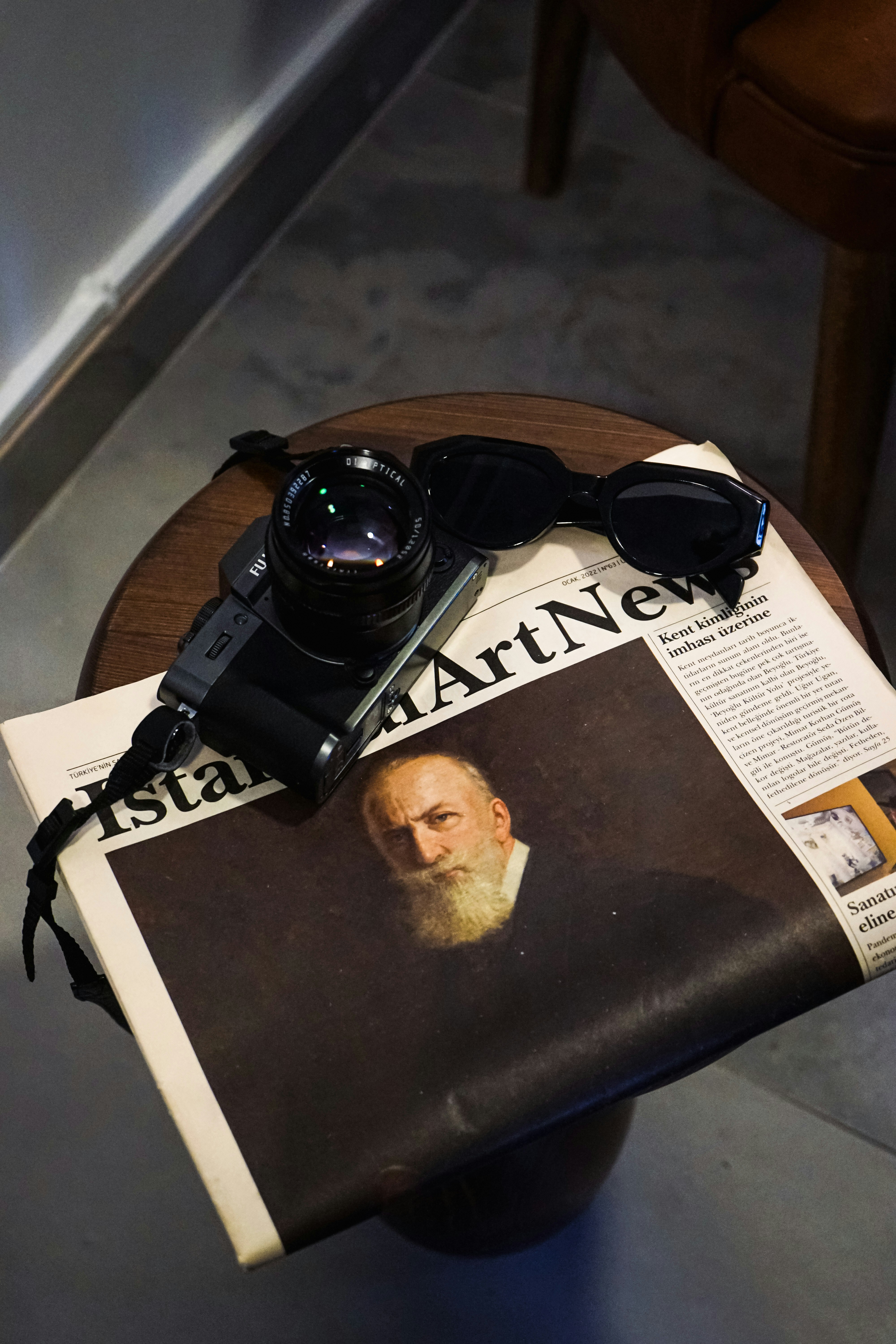 uma câmera e uma revista sobre uma mesa