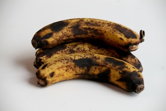 a couple of ripe bananas sitting on top of a white table