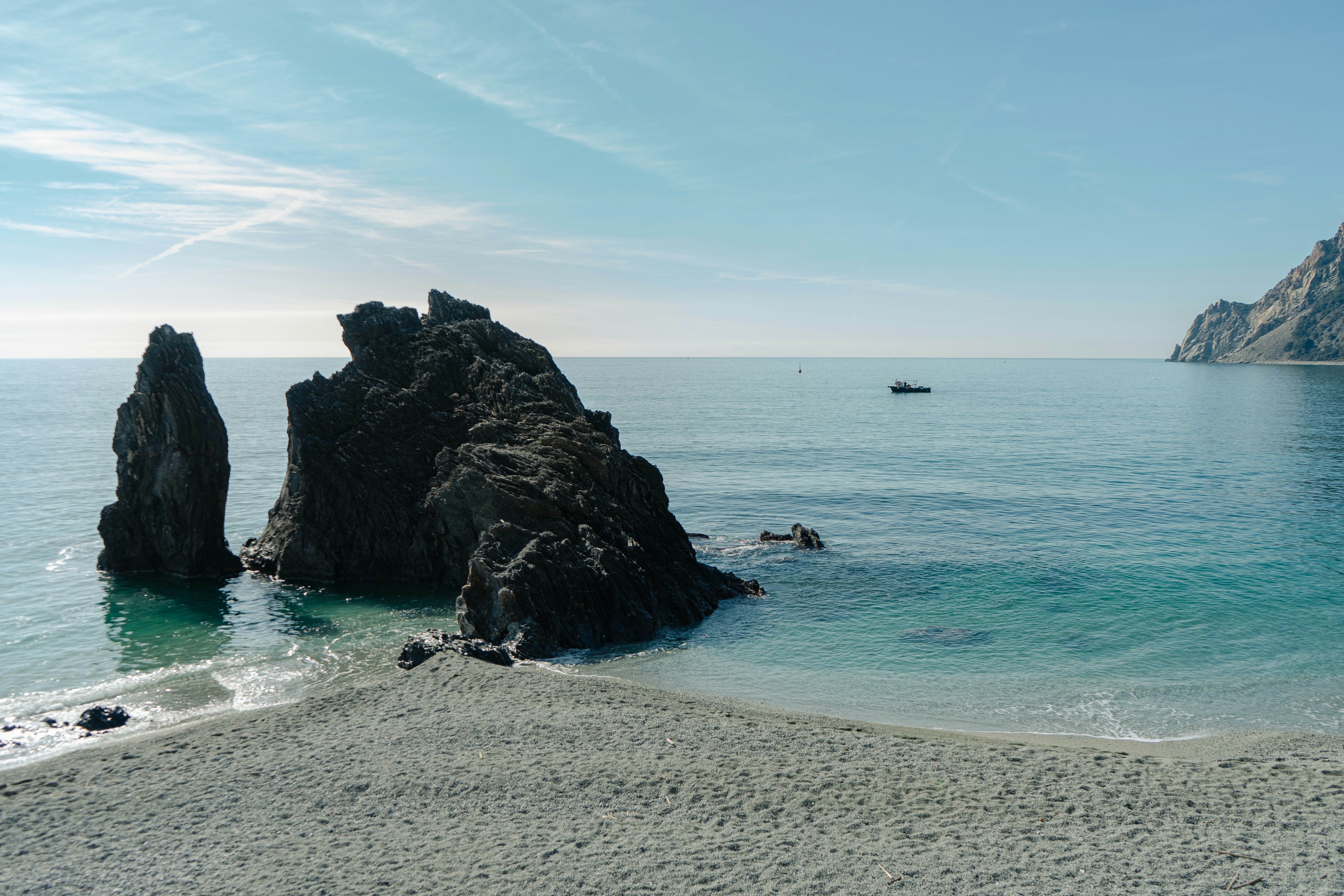 a rocky outcropping in the ocean next to a beach, Lo scoglio di Monterosso a Monterosso Al Mare (Cinque Terre, La Spezia)