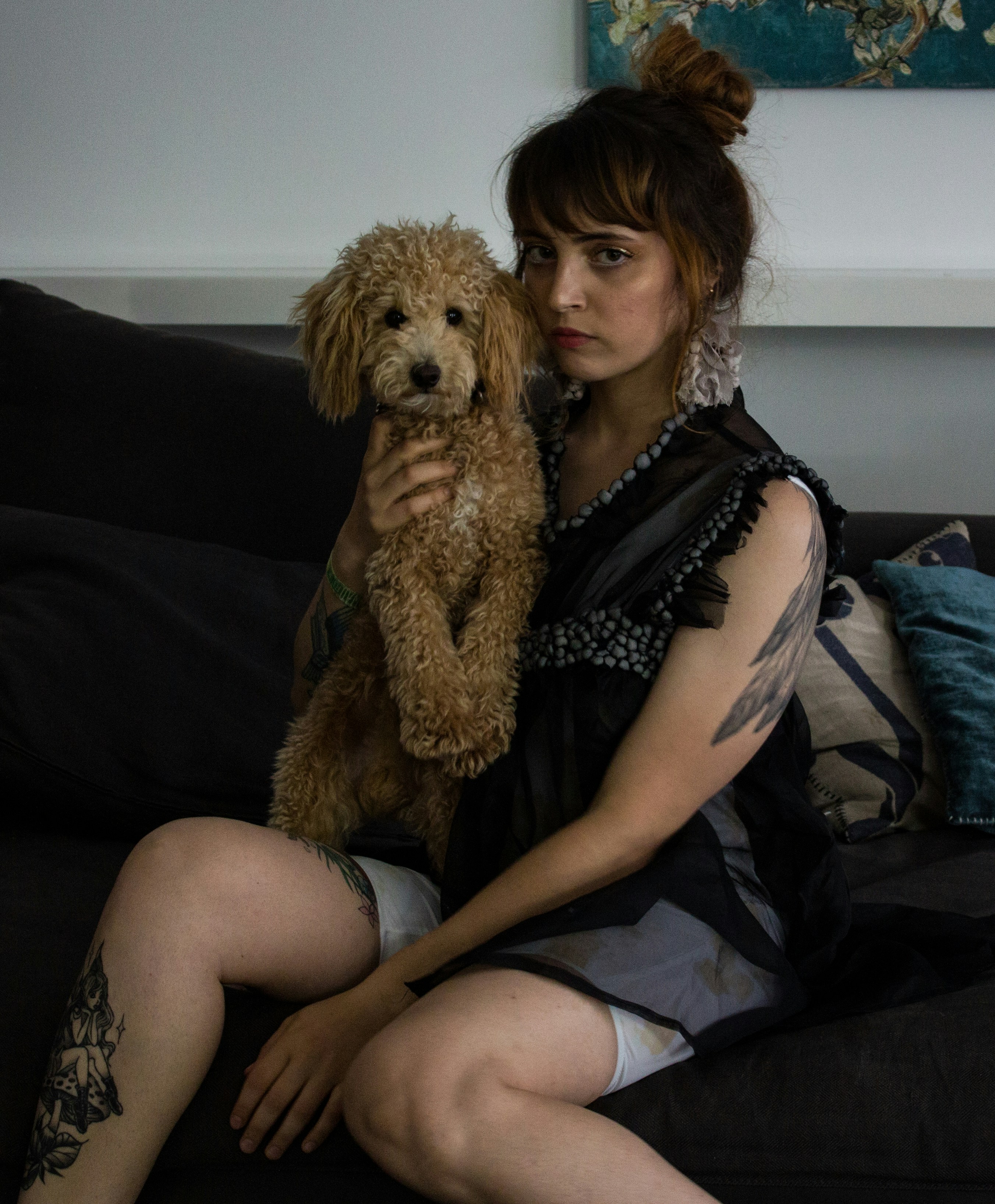 a woman sitting on a couch holding a dog