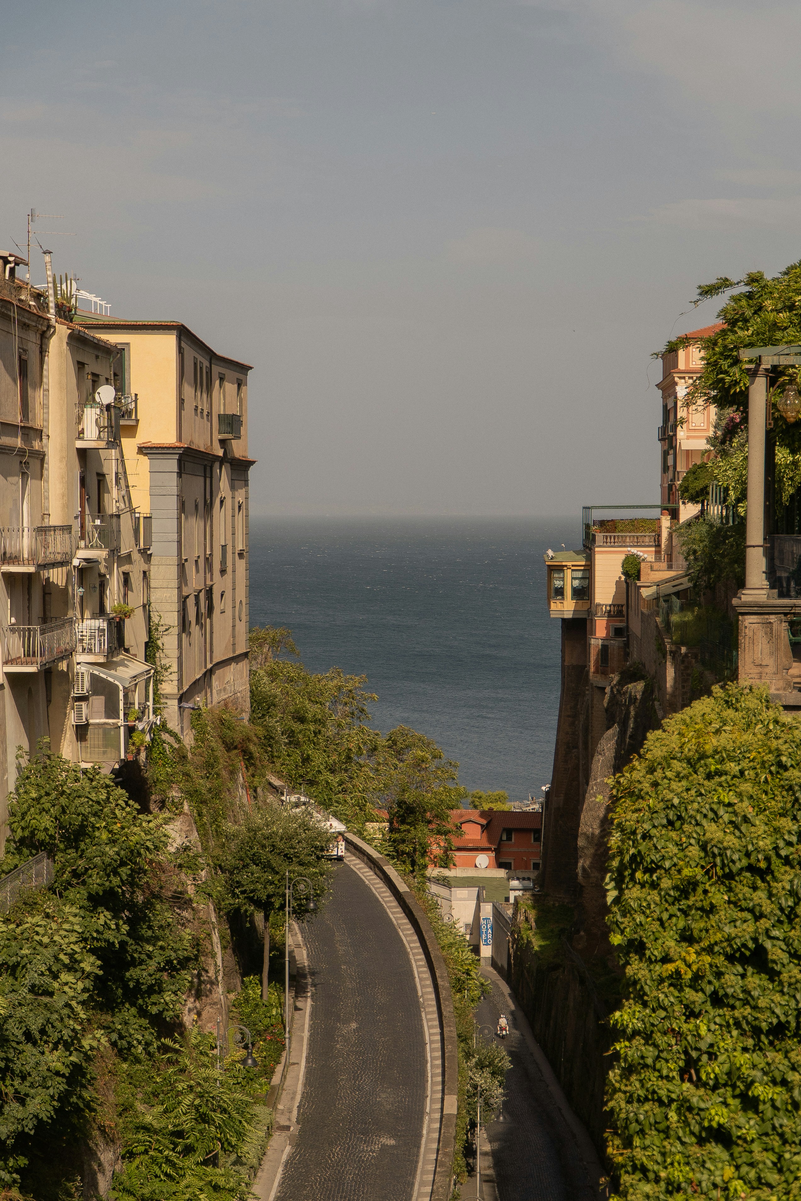 a long winding road next to a large body of water