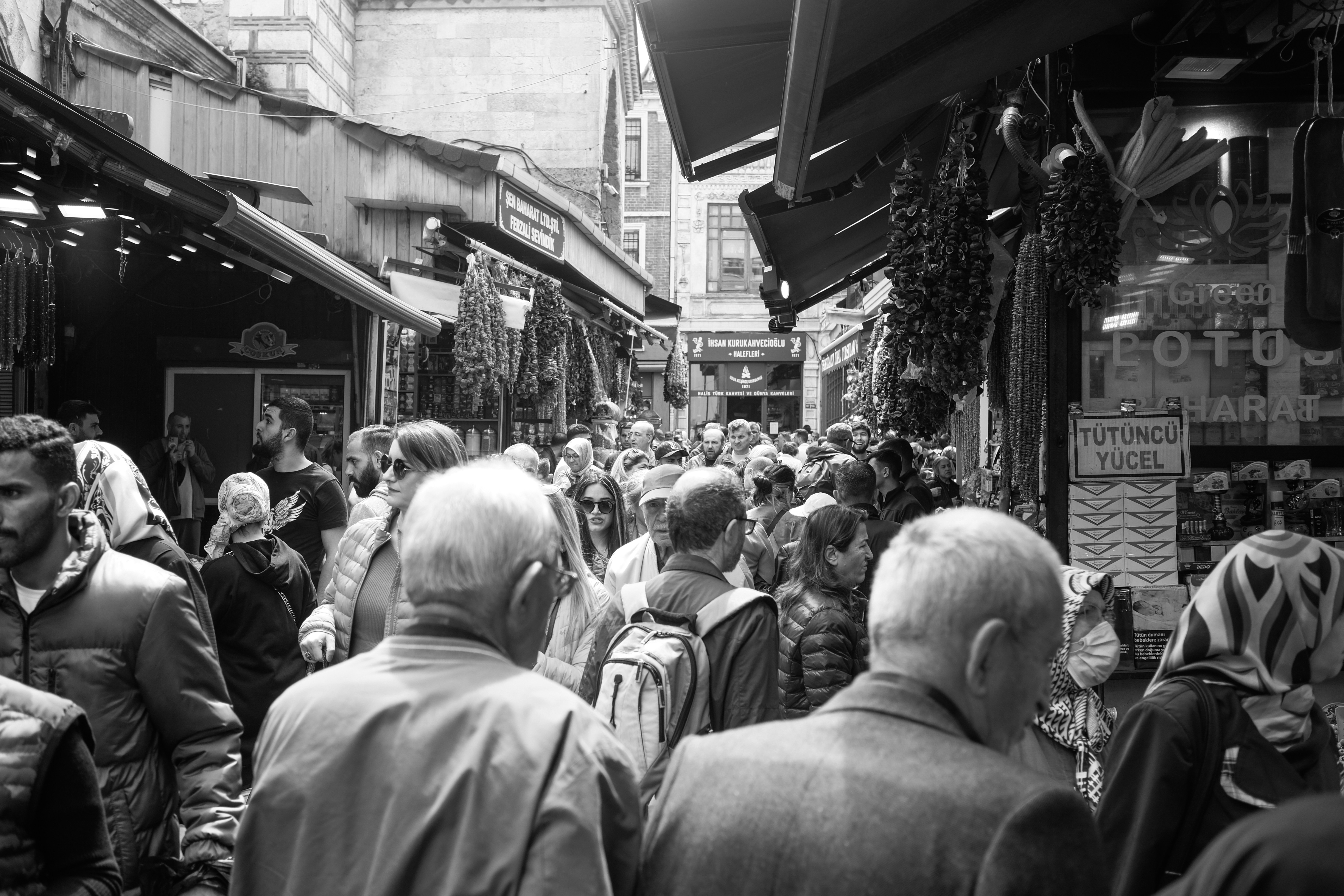 a crowd of people walking down a street next to shops