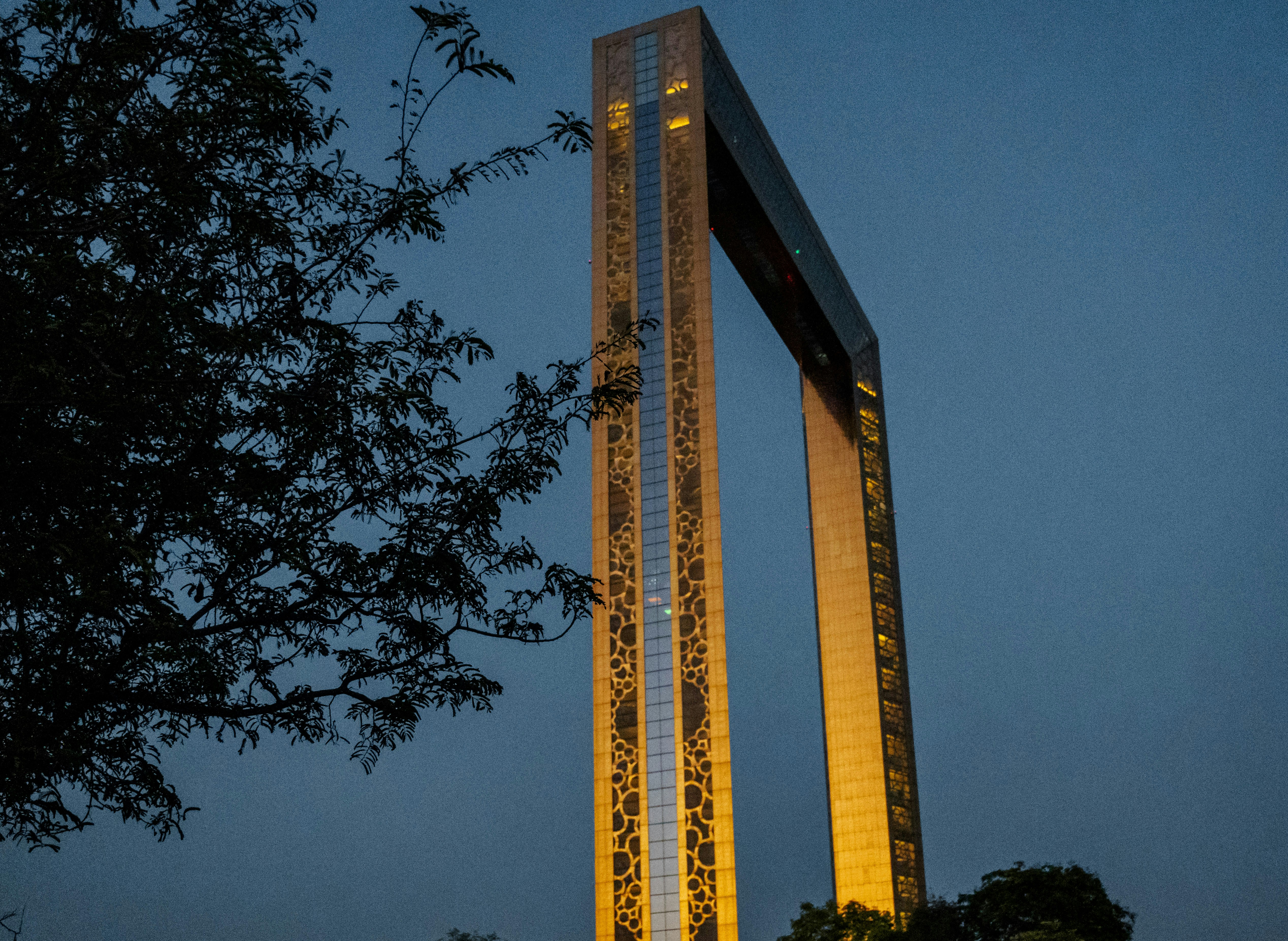 a tall clock tower sitting next to a tree