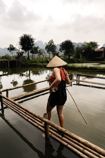 une dame Vietnamienne qui va pêcher dans une rivière 