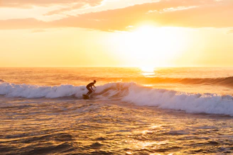 a man riding a wave on top of a surfboard