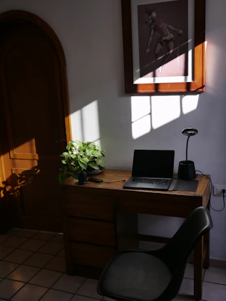 a laptop computer sitting on top of a wooden desk
